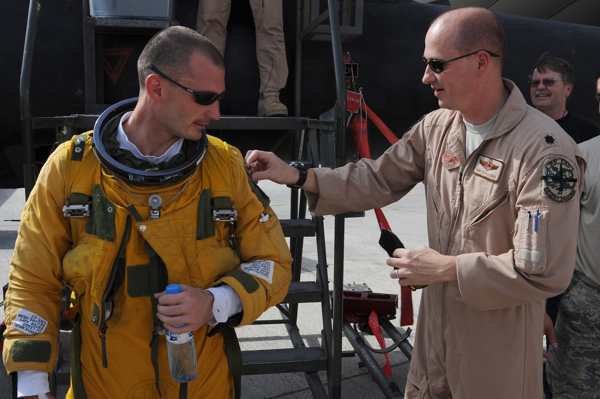 SOUTHWEST ASIA - Lt. Col Kirt Stallings, commander of the 99th Expeditionary Reconnaissance Squadron, tacks on the 1,000 hour patch onto Capt. Joshua Tull, 99th ERS, after his flight at the helm of a U-2 Dragonlady, June 16 at an undisclosed location in Southwest Asia. Captain Tull passed 1,000 hours of flying in a U-2 in just 3 years and 11 days. (U.S. Air Force photo by Senior Airman Brian J. Ellis) (Released)