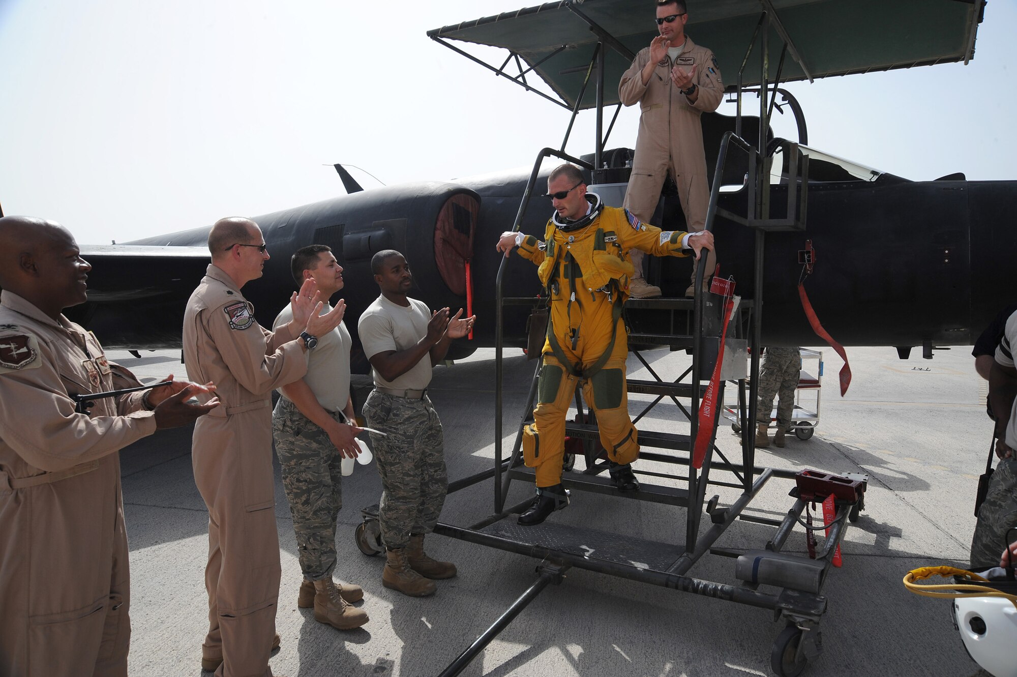 SOUTHWEST ASIA -- Capt. Joshua Tull, a member of the 99th Expeditionary Reconnaissance Squadron, exits his U-2 Dragonlady to a round applause, June 16 at an undisclosed location in Southwest Asia. Captain Tull passed 1,000 hours of flying in a U-2 in just 3 years and 11 days. (U.S. Air Force photo by Senior Airman Brian J. Ellis) (Released)