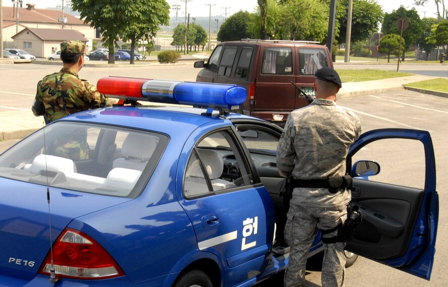 Korean Air Force Tech. Sgt. Heo Sungsoo and U.S. Air Force Staff Sgt. Adam Fike prepare to search a vehicle on Osan Air Base, June 18.  This is the first time the 51st Security Forces Squadron and ROKAF Air Police have patrolled together.  In the future the two units will continue the patrols, allowing better communication between the two services. (U.S. Air Force photo/Senior Airman Stephenie Wade)