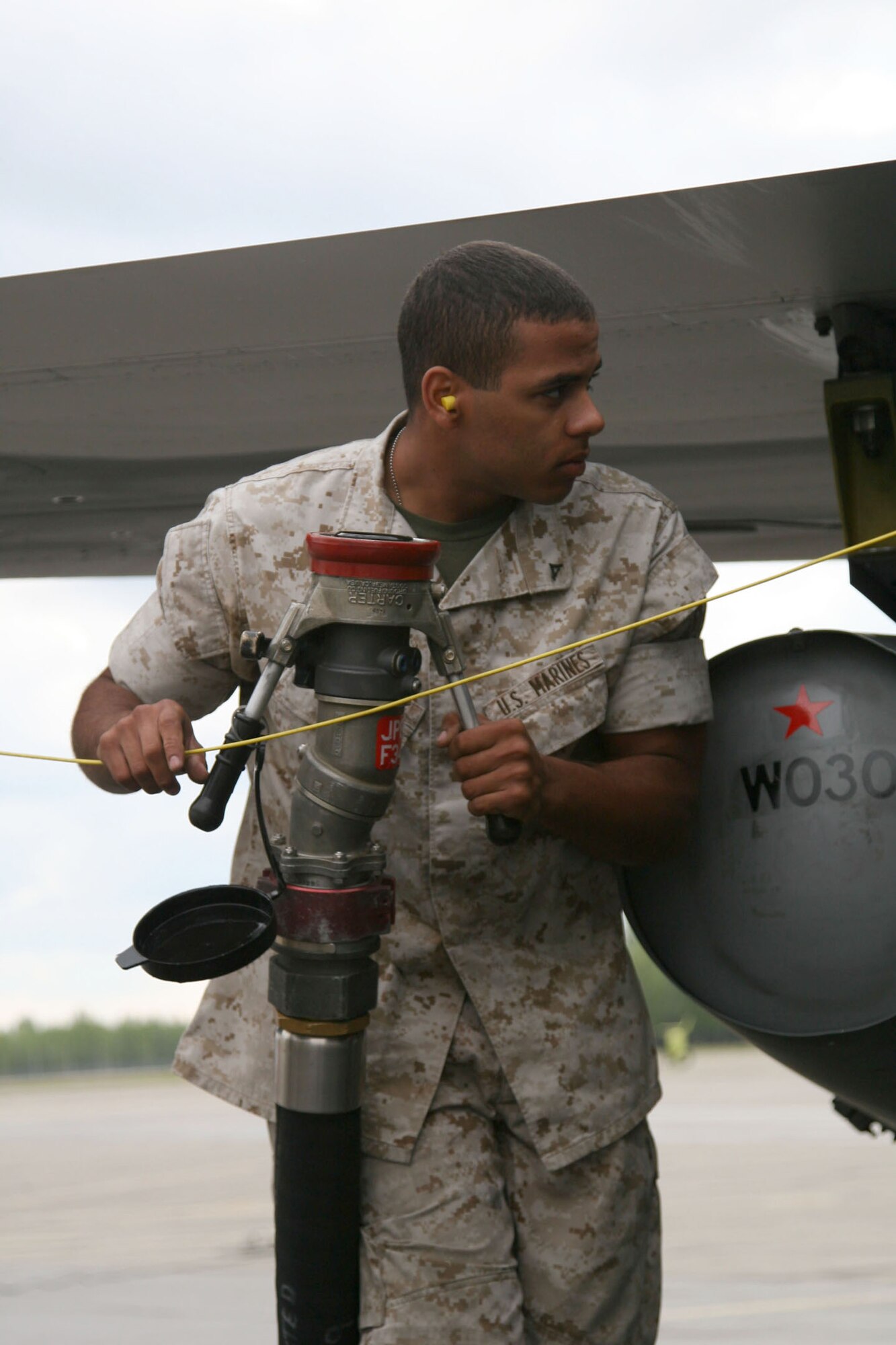 EIELSON AIR FORCE BASE, Alaska -- Lance Cpl. Justin Moore, MWSS-171 bulk fuel specialist, extends the hose from an R-11 fuel truck over to a jet for fueling on the flightline of Eielson Air Force Base, Alaska, June 19. Moore is participating as part of Exercise Northern Edge 2009. (U.S. Marine Corps photo/Staff Sgt. Andrew Miller)