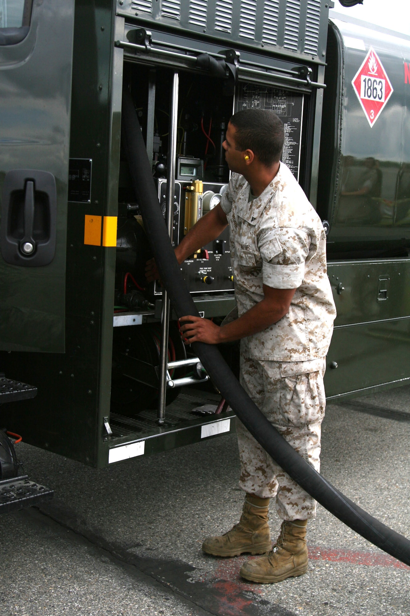 EIELSON AIR FORCE BASAE, Alaska -- Lance Cpl. Justin Moore, MWSS-171 bulk fuel specialist, extends the hose from an R-11 fuel truck for the fueling of a jet on the flightline of Eielson Air Force Base, Alaska, June 19. Moore is participating as part of Exercise Northern Edge 2009. (U.S. Marine Corps photo/Staff Sgt. Andrew Miller)
