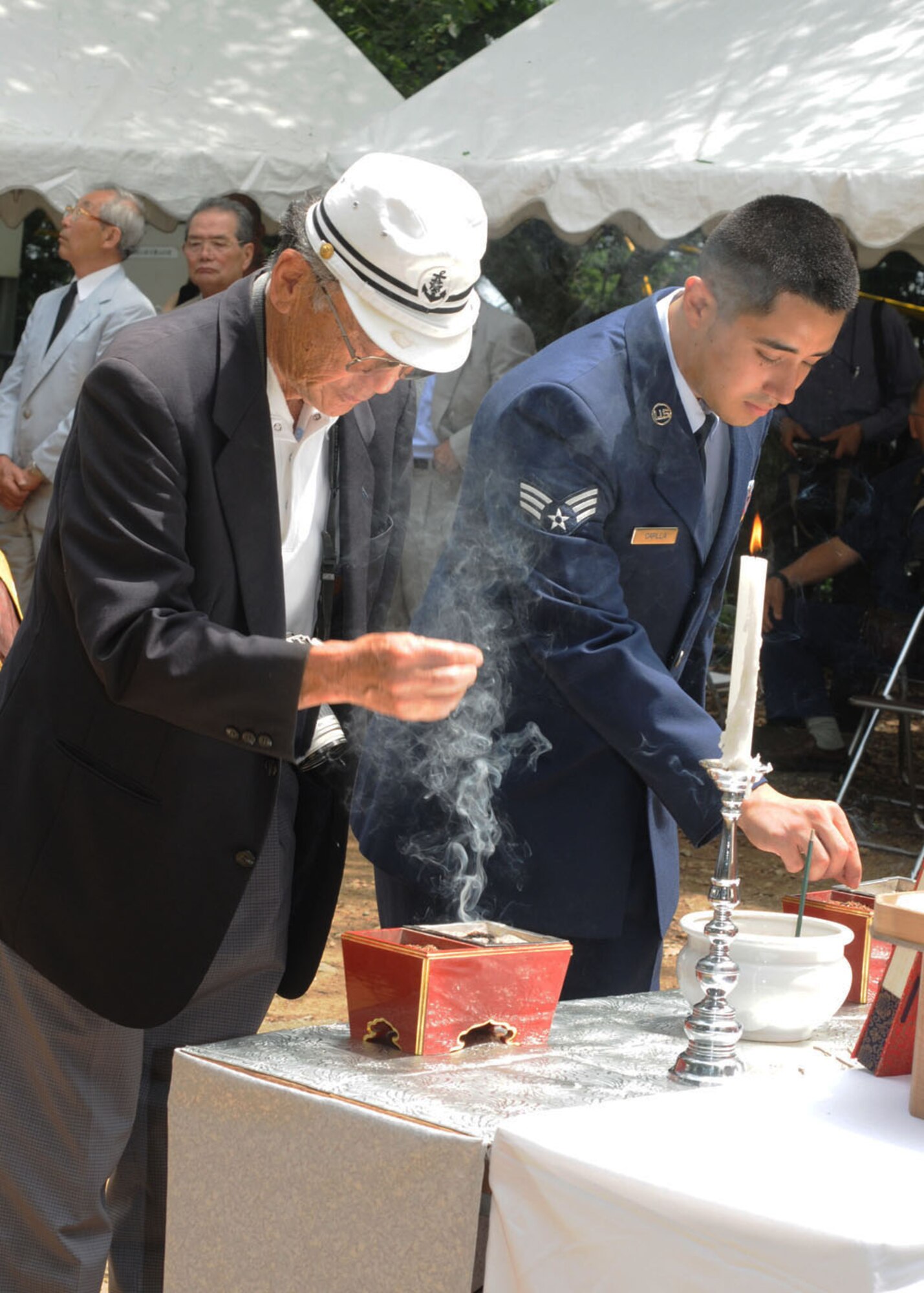 YOKOTA AIR BASE, Japan -- Senior Airman Luis Capilla, 374th Force Support Squadron, performs a memorial ritual with a World War II Japanese Imperial Navy veteran June 20,  In remembrance of those who perished in the B-29 crash over Shizuoka, Japan June 20, 1945. Since 1972, Yokota Airmen have participated in US-Japan joint memorial service for the victims of the the crash. (U.S. Air Force photo/ Staff Sgt. Veronica Pierce)