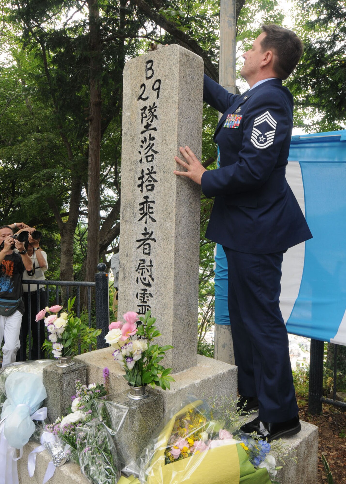 YOKOTA AIR BASE, Japan --  Chief Master Sgt. John Fitton, 730th Air Mobility Squadron, pours the traditional American bourbon whiskey over the B-29 memorial on Mt. Shizuhata June 20. Since 1972, Yokota Airmen have participated in the US-Japan joint memorial service for the victims of the crash. (U.S. Air Force photo/ Staff Sgt. Veronica Pierce)