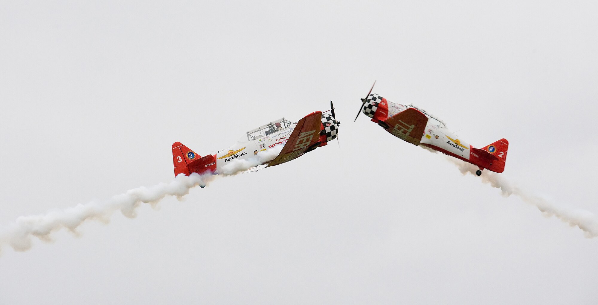 Two members of the Aeroshell Aerobatic Team cross during their performance at the Dover Air Force Base Open House and Air Show. (U.S. Air Force photo/Tom Randle)