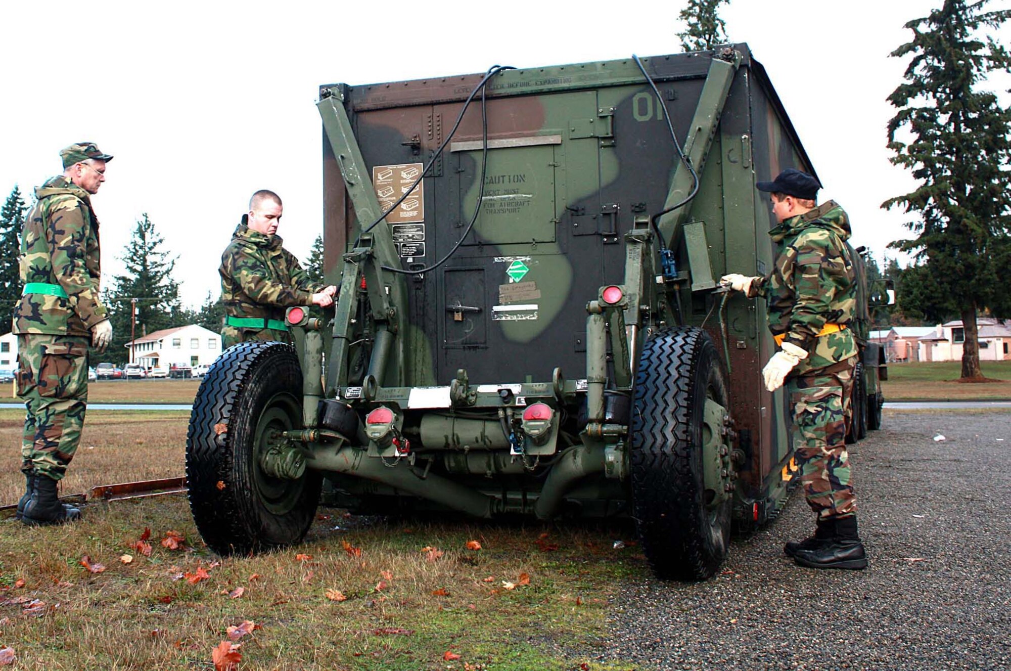 From left to right are Master Sgt. Kevin King, Tech. Sgt. Christopher Roening, and Tech. Sgt. Monty Clayton from the 446th Airlift Control Flight, McChord Air Force Base, Wash., prepare to unload a Mobile Air Reporting and Command shelter during an excersize at Ft. Lewis.