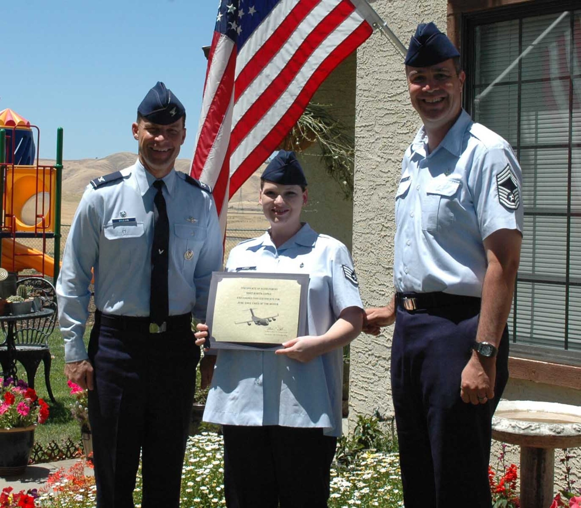 Col. Mark Dillon, 60th Air Mobility Wing commander and Chief Master Sgt. Steven Wiggins, acting 60th AMW command chief, present Staff Sgt. Robyn Lopez, 60th Medical Operations Squadron, with the Yard of the Month award. Sergeant Lopez’s yard was recognized for pride in ownership, outstanding curb appeal and overall appearance. (U.S. Air Force photo/Senior Airman Sara Weber)