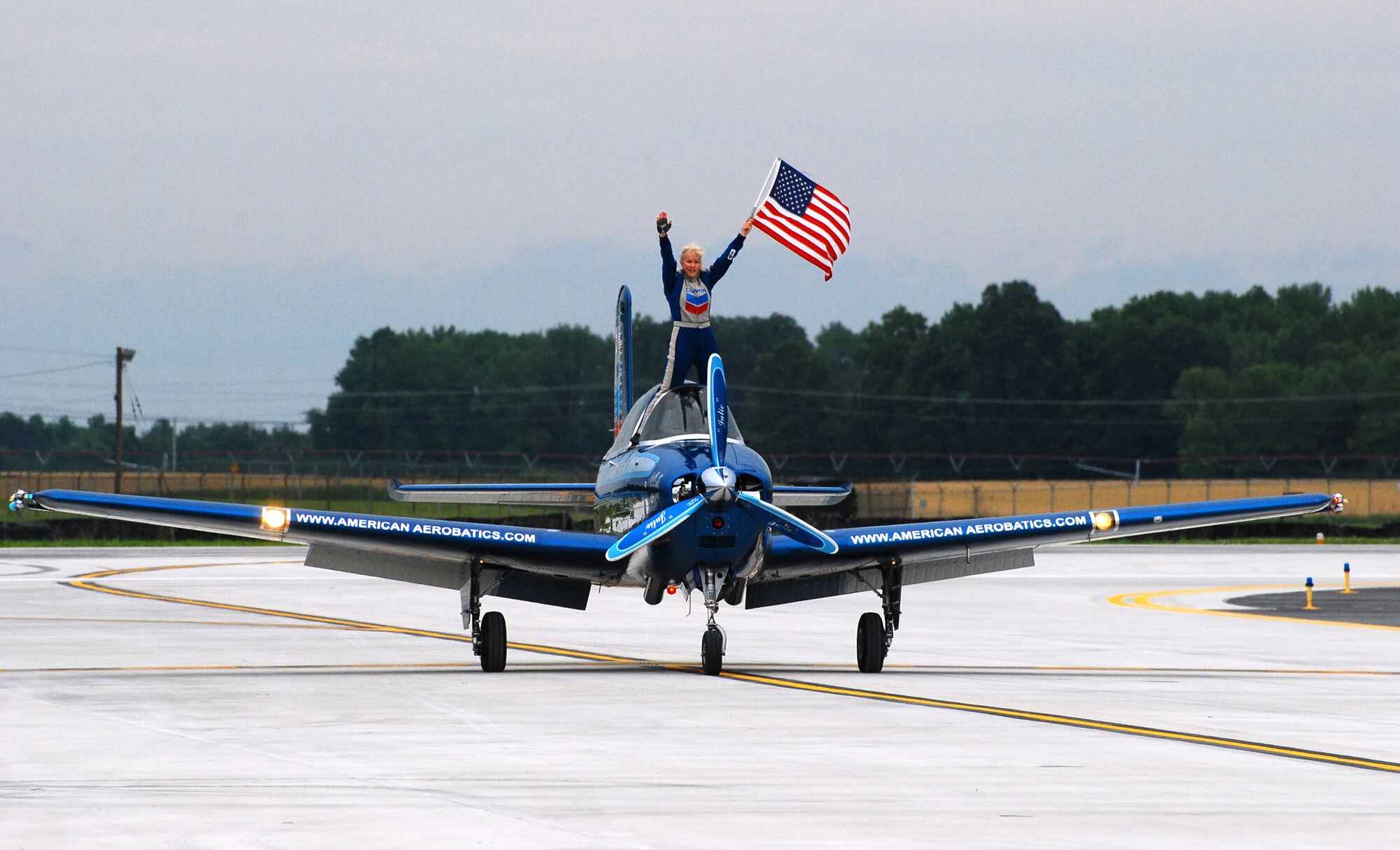 Julie Clark stands outside of the cockpit of her Chevron Mentor T-35 to greet the crowd during the 2009 Dover Air Force Base Open House and Air Show June 21. Several flying acts took place, including Ms. Clark's aerobatic demonstration, at the weekend event. (U.S. Air Force photo/Staff Sgt. Steve Lewis)