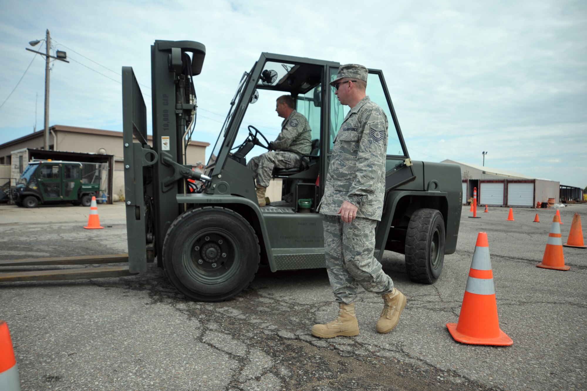 Tech. Sgt. Christopher Devoid walks alongside a forklift driven by Master. Sgt. Leo Ritter during the 931st Air Refueling Group's drill weekend in June. Sergeant Devoid  helped Sergeant Ritter make sharp turns through a course of orange cones while training near the headquarters of the 931st Civil Engineer Squadron at McConnell Air Force Base, Kan. Both sergeants are Reservists assigned to the squadron. (U.S. Air Force photo/Tech. Sgt. Jason Schaap)