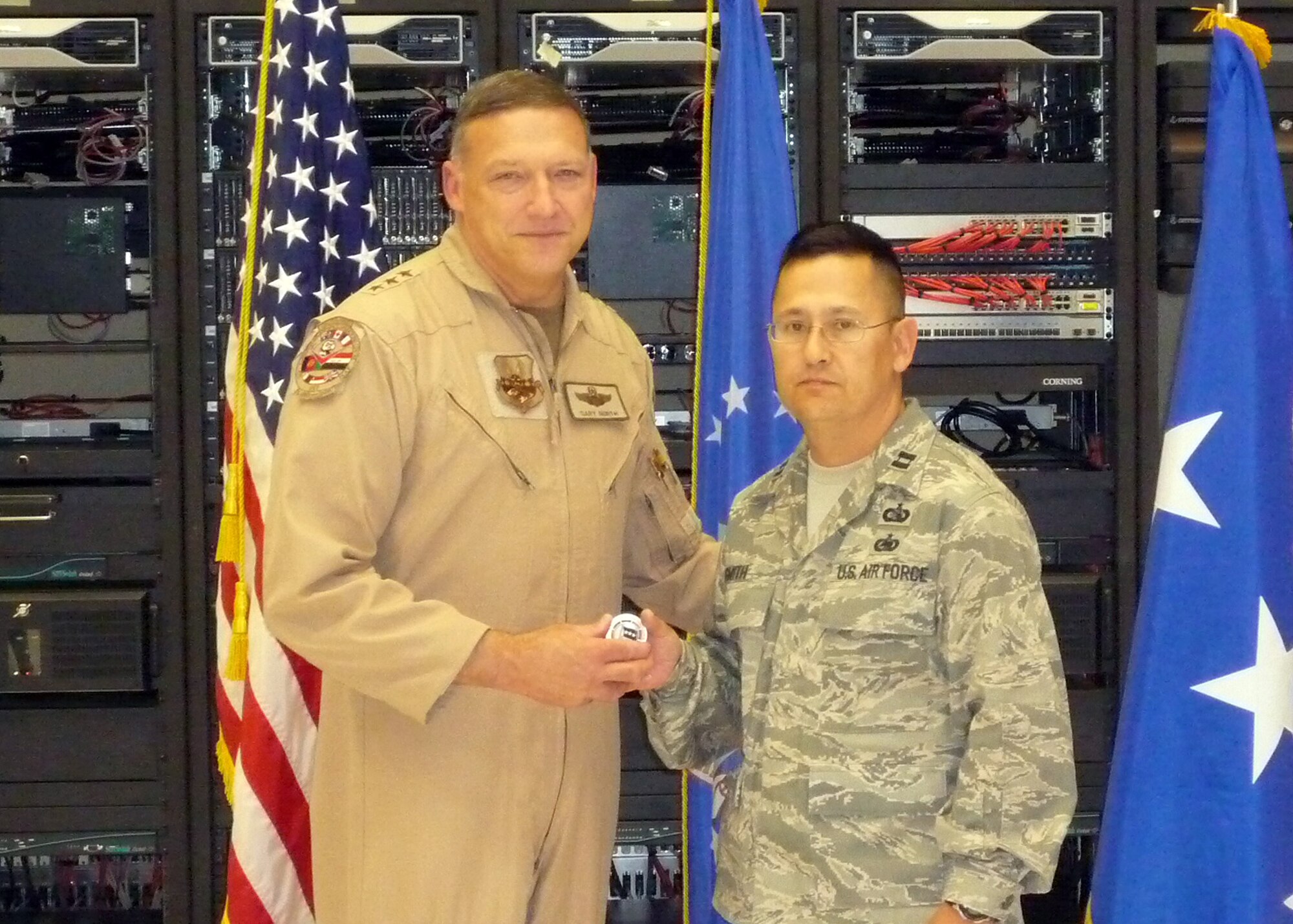 Lt. Gen. Gary L. North, 9th Air Force and U.S. Air Forces Central Command commander, coins Capt. Dennis Smith of the 350th Electronic Systems Wing for his work as the Air and Space Operations Center Weapon System program manager during his deployment to a base in Southwest Asia. (Courtesy photo)