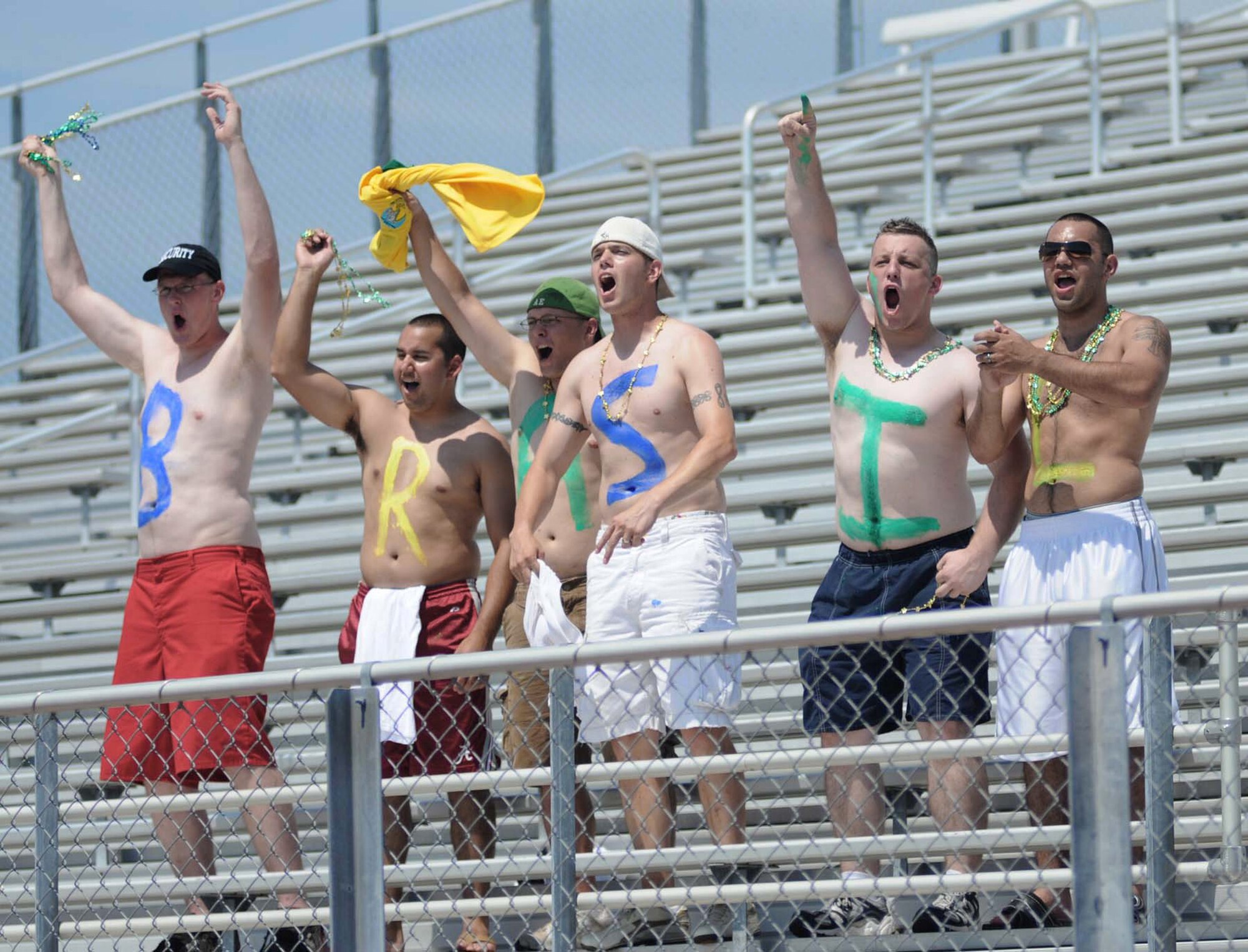 Jacob Tarver (left to right), David MacDonald, Caleb Foy, Christopher Turknett and Juan Rivera cheer the Brazilian team to a 1-0 victory during the title game of the 5th Counseil du International Sports Militaire Women's Soccer Championship tournament June 13 at Biloxi High Stadium in Mississippi. The cheering squad is from the 81st Security Forces Squadron, one of the units on base that "adopted" one of the seven teams competing. Keesler Air Force Base hosted the international soccer showcase that began June 6. (U.S. Air Force photo/Kemberly Groue)