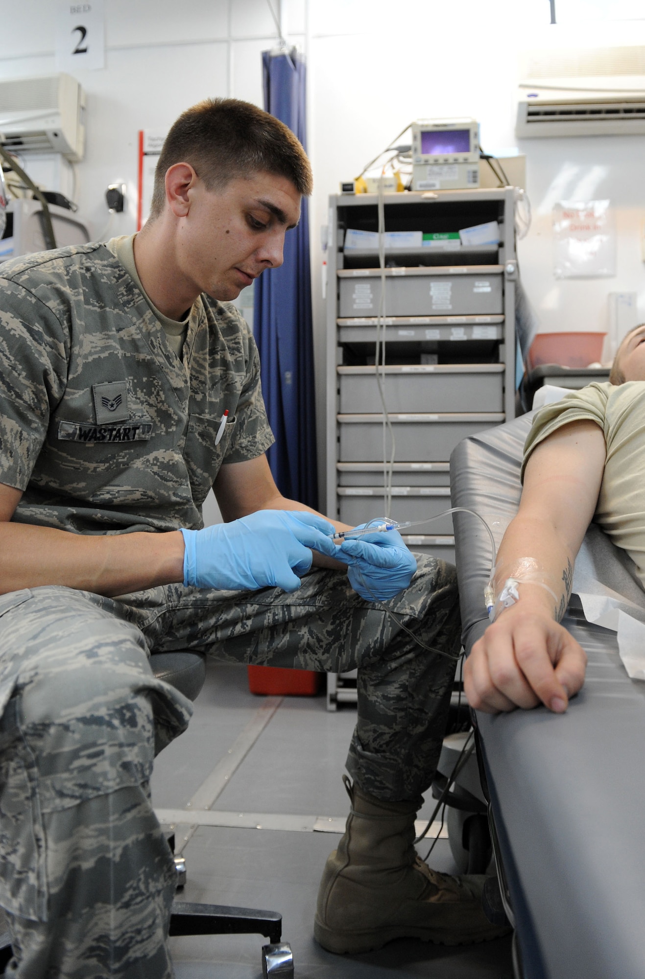 Staff Sgt. Thomas Wastart, 477th Expeditionary Medical Squadron medical technician, administers medication via intravenous line at Sather Air Base June 12. Sergeant Wastart, a native of Stevens Point, Wis., is deployed from the 115th Fighter Wing, Wis. (U.S. Air Force photo/Senior Airman Tiffany Trojca) 