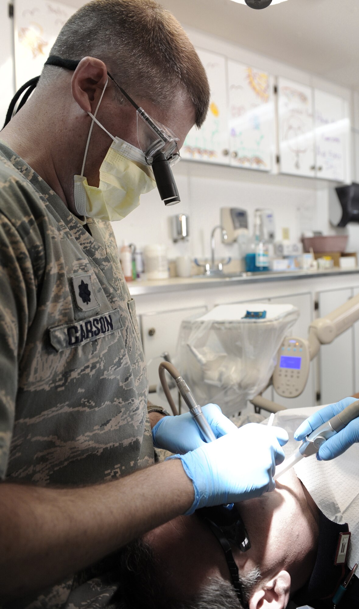 Lt. Col. Clarence Carson, an 447th Expeditionary Medical Support Squadron dental-services chief, performs a dental procedure on a patient at Sather Air Base June 12. Colonel Carson, a native of Yankton, S.D., is deployed here from the 185th Air Refueling Wing in Sioux City, Iowa. (U.S. Air Force photo/Senior Airman Tiffany Trojca)