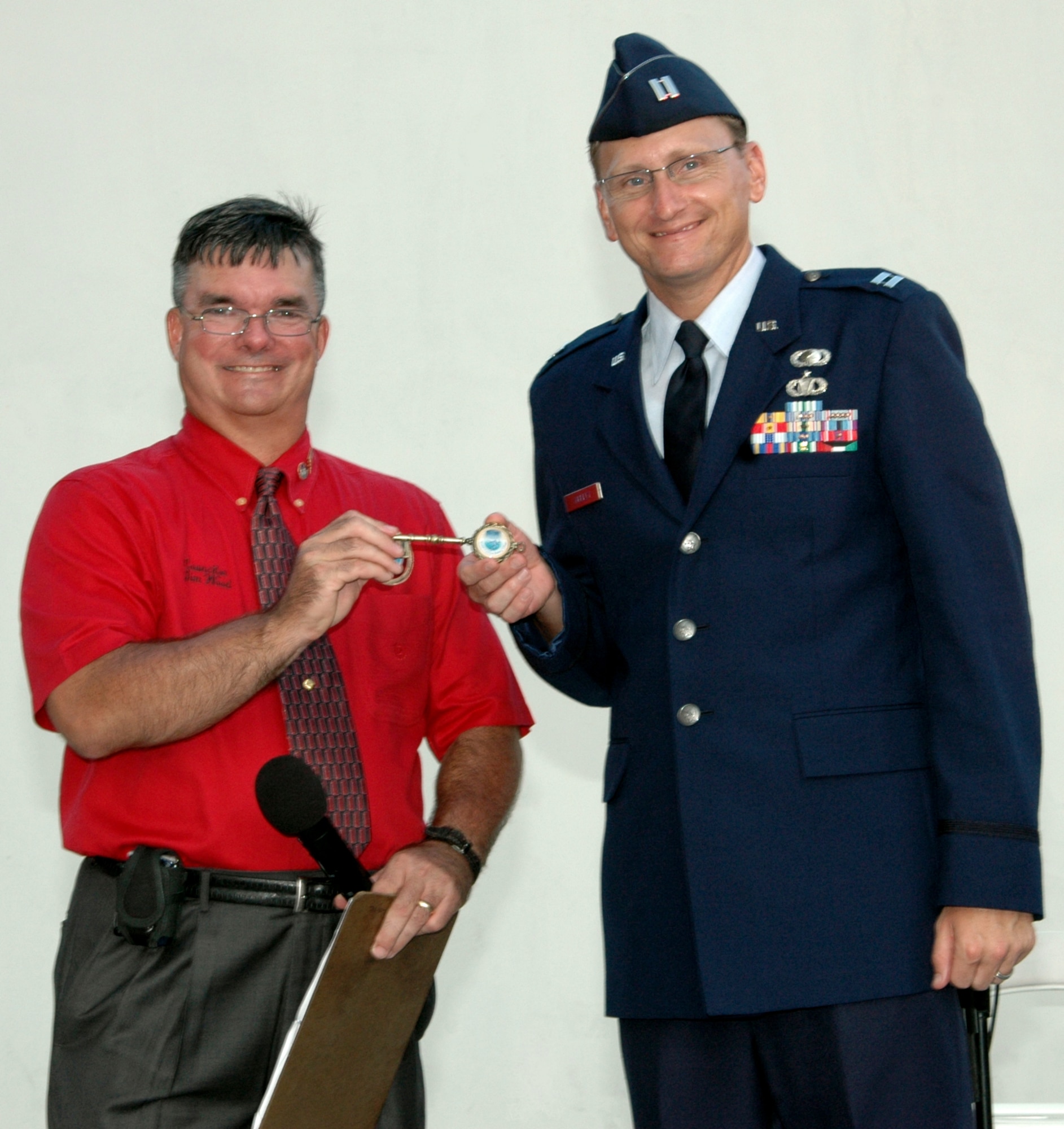 Capt. Brian Hurley (right), a contracting officer with the Air Armament Center, accepts a key to the city of Destin from city councilman, Jim Wood, during the annual Red, White and Blue Celebration June 18. (U.S. Air Force Photo/Jasmine DeNamur)