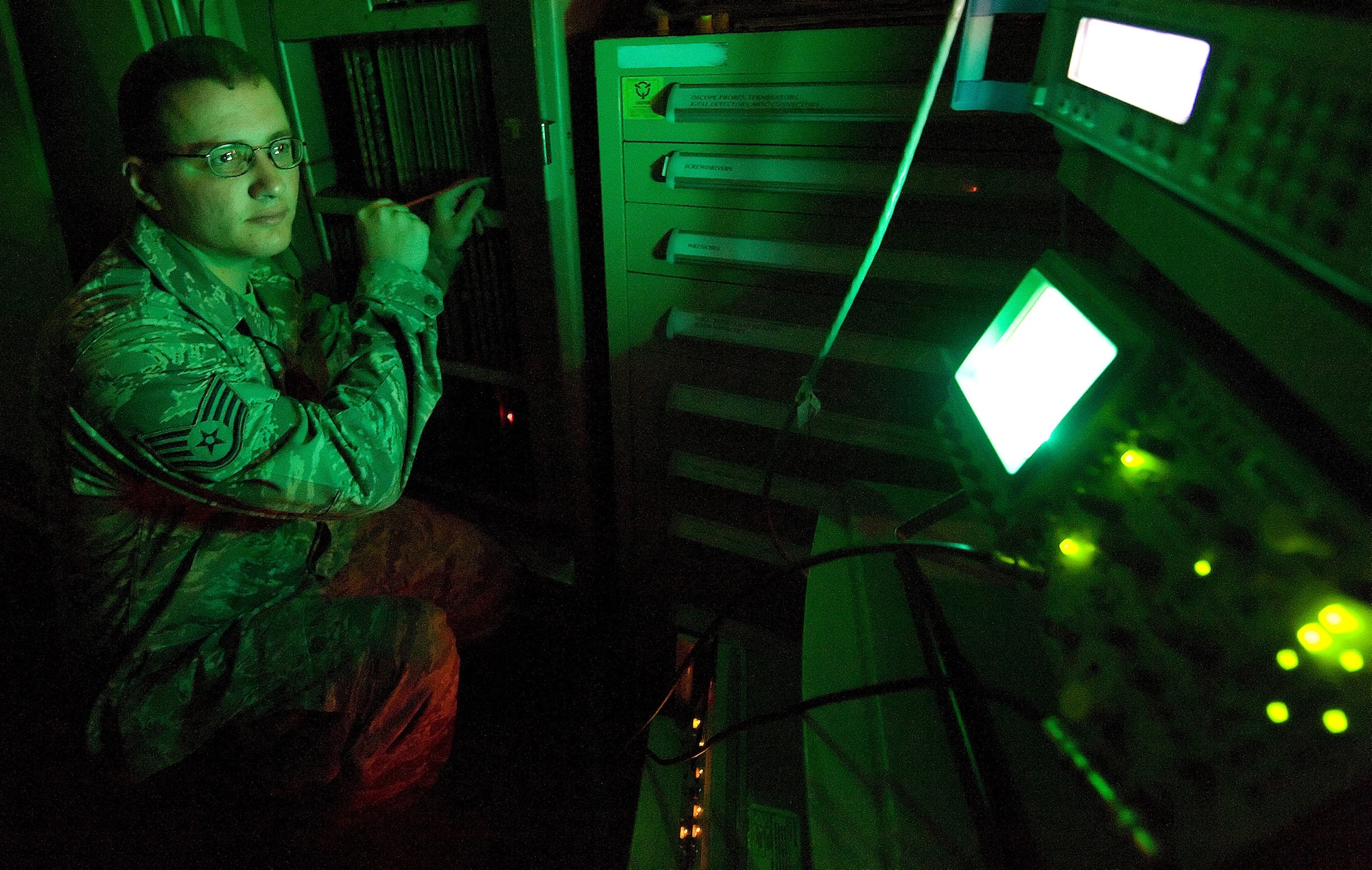 Staff Sgt. Josh Wilfong, 436th Communications Squadron ground radar systems technician, keeps an eye on the oscilloscope, which displays electronic video signals, as he adjusts the signal strength inside the surveillance radar?s processor cabinet. It is important to adjust the signal strength to give the air traffic controllers a clear display of all air traffic above Dover Air Force Base. (Air Force photo/ Jason Minto)