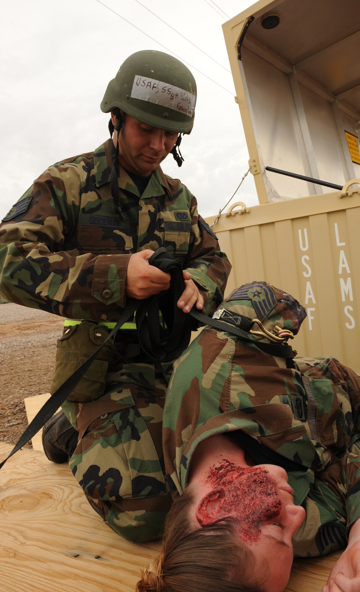 Staff Sgt. Richard Goodman, 49th Materiel Maintenance Squadron, uses a simulated tourniquet on Staff Sgt. Karen Stephens, 49th Maintenance Squadron, who simulates losing a limb and suffering from burns after as attack on Basic Expeditionary Airfield Resources Base, June 18, at Holloman Air Force Base, N.M. The scenario called for mass causalities and Airmen from 49 MSS were required to perform self-aid and buddy care. (U.S. Air Force photo/Airman 1st Class Sondra Escutia)