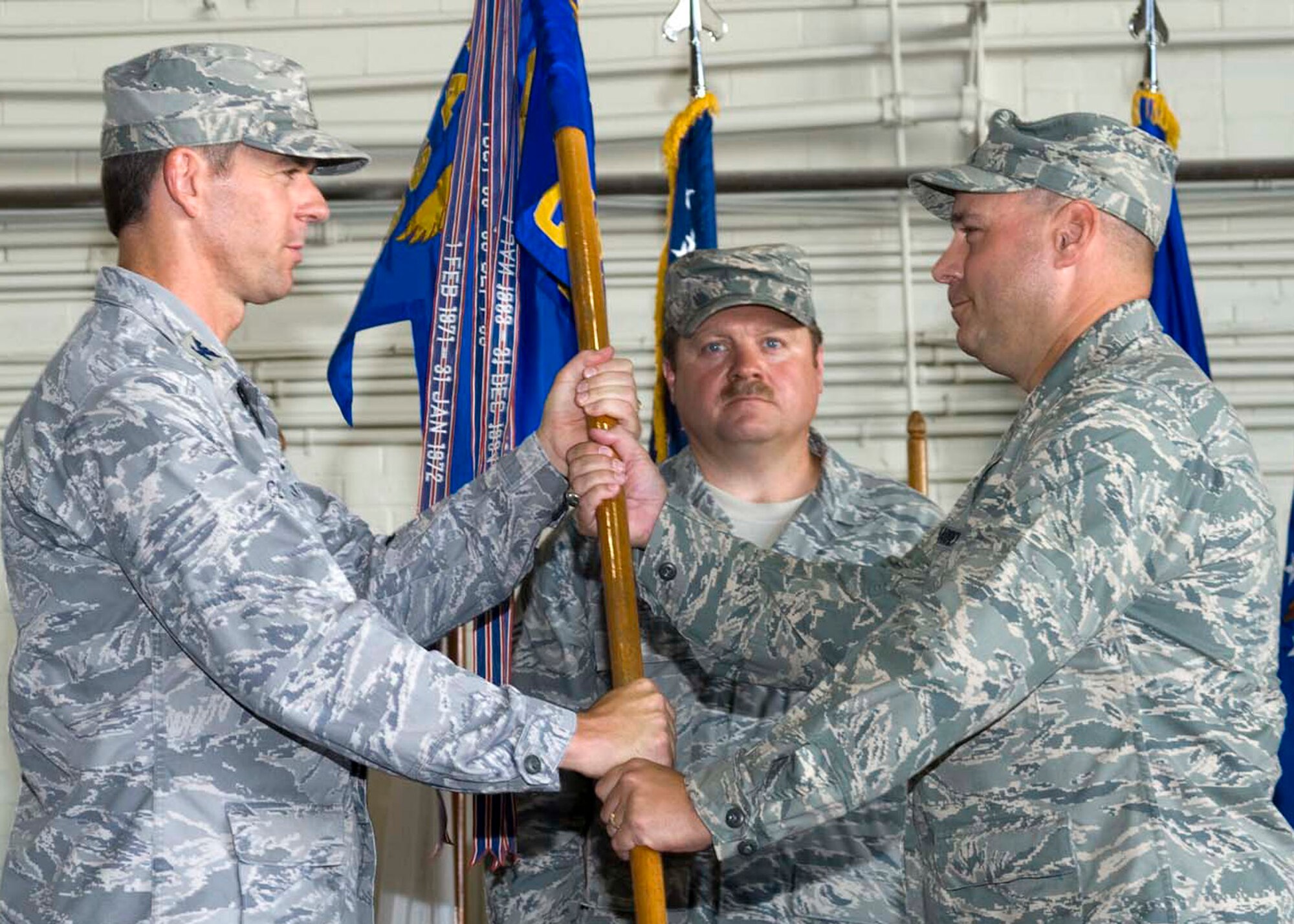 Col. Bruce McClintock, 96th Air Base Wing commander, passes the 96th Civil Engineer Group guidon to Col. David Maharrey during a change of command ceremony June 17 at Eglin Air Force Base, Fla.  Colonel Maharrey takes command of the group from Col. Dennis Yates.  (U.S. Air Force photo/Bruce Hoffman.)
