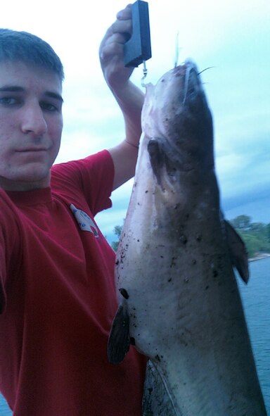 OFFUTT AIR FORCE BASE, Neb. -- Airman Matthew Phillips holds up his 13-lb catfish recently caught at the base lake. The area is home to a variety of wildlife and is maintained by the 55th Force Support Squadron.  (Courtesy Photo)