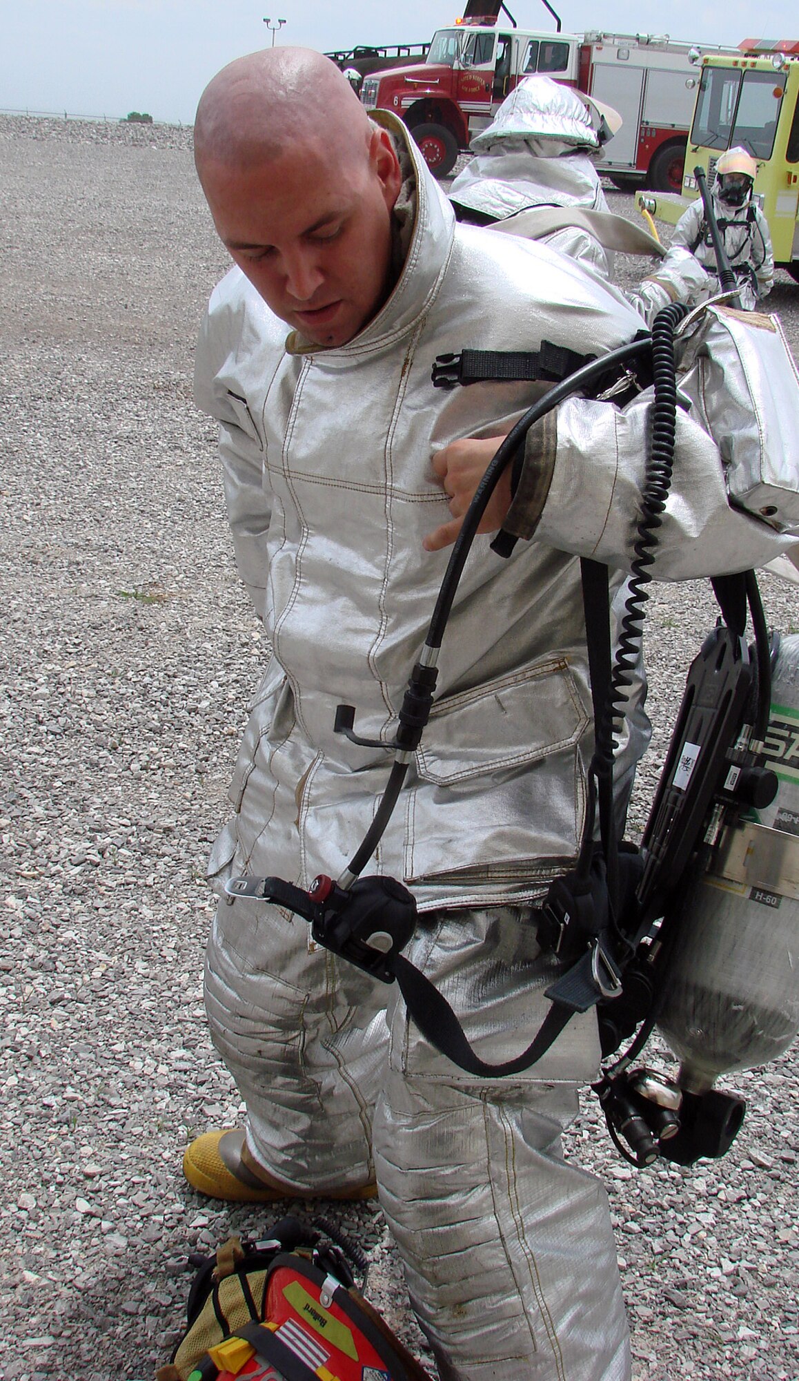 Staff Sgt. Michael Brick, a fire engine crew chief from the 56th Civil Engineering Squadron, Luke AFB, Ariz., puts on a protective suit before training on Vance aircraft. Sergeant Brick is part of the 31-man team of firefighters deployed to Vance during the labor dispute. (Photo/Senior Master Sgt. Russell Eidenschink)