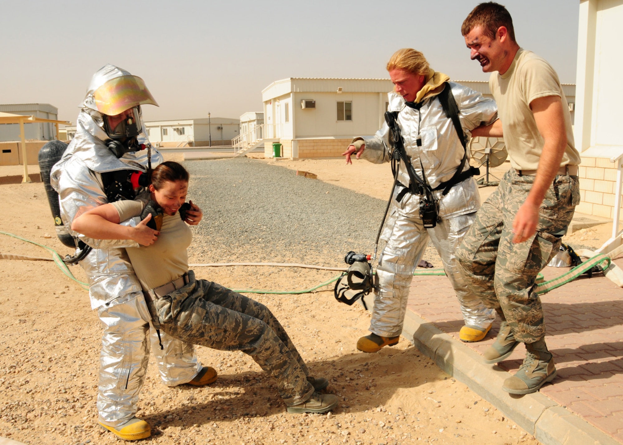 SOUTHWEST ASIA -- Firefighters from the 386th Expeditionary Civil Engineer Squadron assist simulated victims out of a simulated dorm fire during an exercise at an air base in Southwest Asia, June 22. If the victim is conscience and has the ability to walk they are assisted to the medical collection point, if they are unconscious or incapable of walking they are then carried. (U.S. Air Force photo/Senior Airman Courtney Richardson)