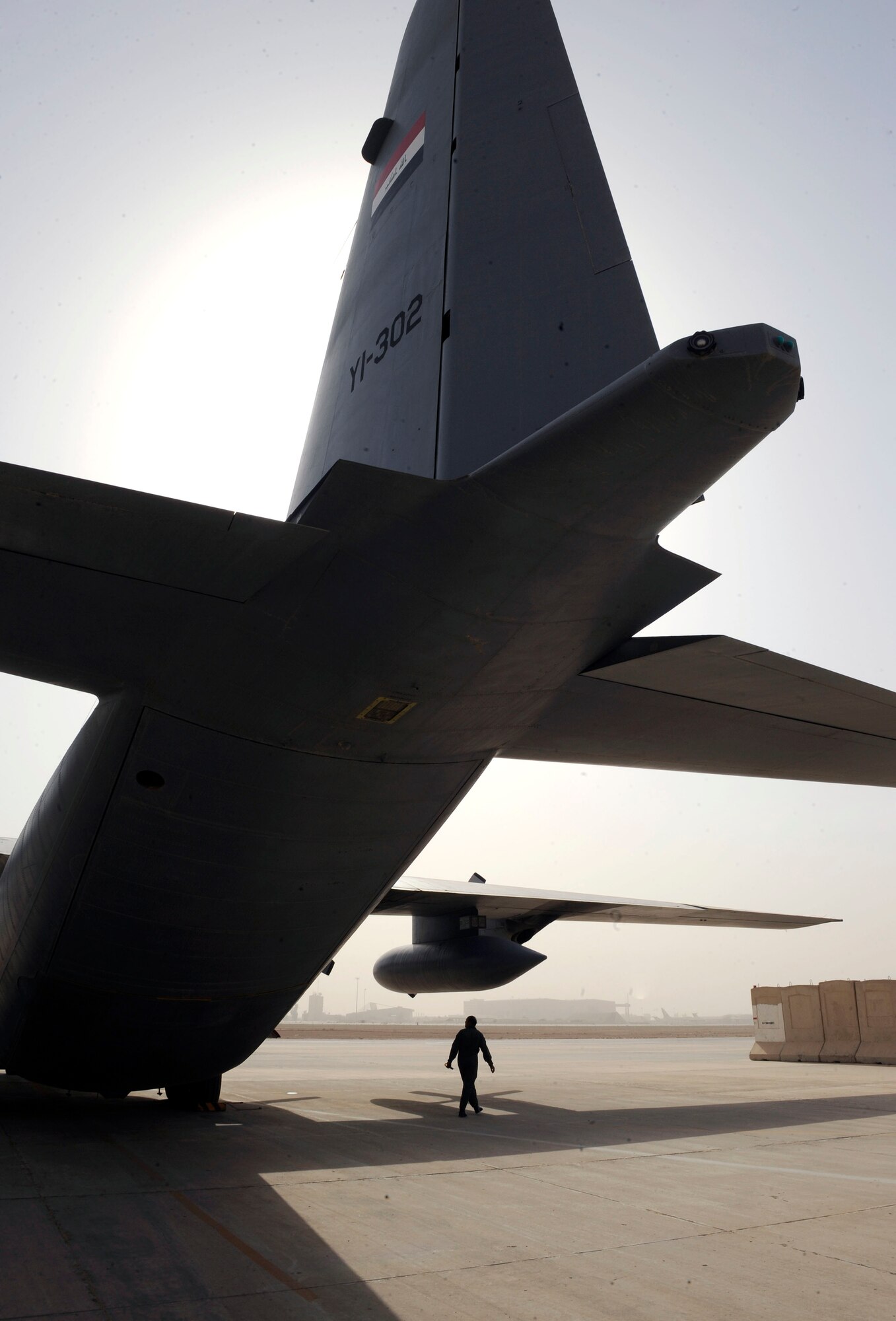 An Iraqi air force crew chief inspects a C-130 during a pre-flight inspection at New al-Muthana Air Base, Iraq June 21, 2009. The flight was destined for Najaf, Iraq to drop off three pallets of humanitarian aid and donated supplies to displaced families at Camp Al-Manathera.  (U.S. Air Force photo by Senior Airman Jacqueline Romero)