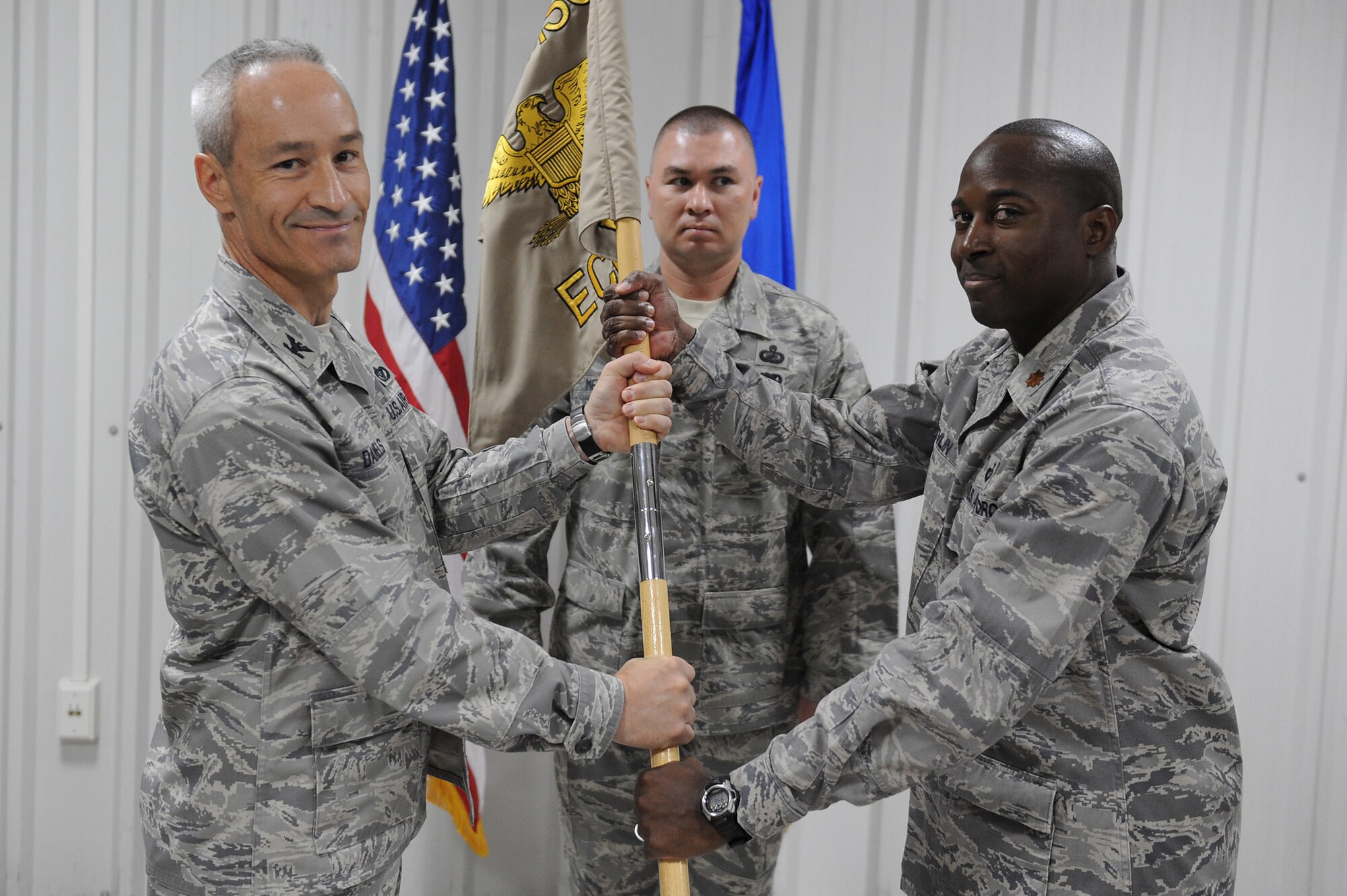 SOUTHWEST ASIA - Maj. Ronnie Devlin takes command of the 380th Expeditionary Contracting Squadron as he receives the squadron guidon from Col. Darren Daniels, 380th Expeditionary Mission Support Group, commander, June 20 at an undisclosed location in Southwest Asia. Major Devlin comes from Kadena AB, Okinawa, Japan to lead the Airmen of the 380th ECONS. (U.S. Air Force photo by Senior Airman Brian J. Ellis) (Released)