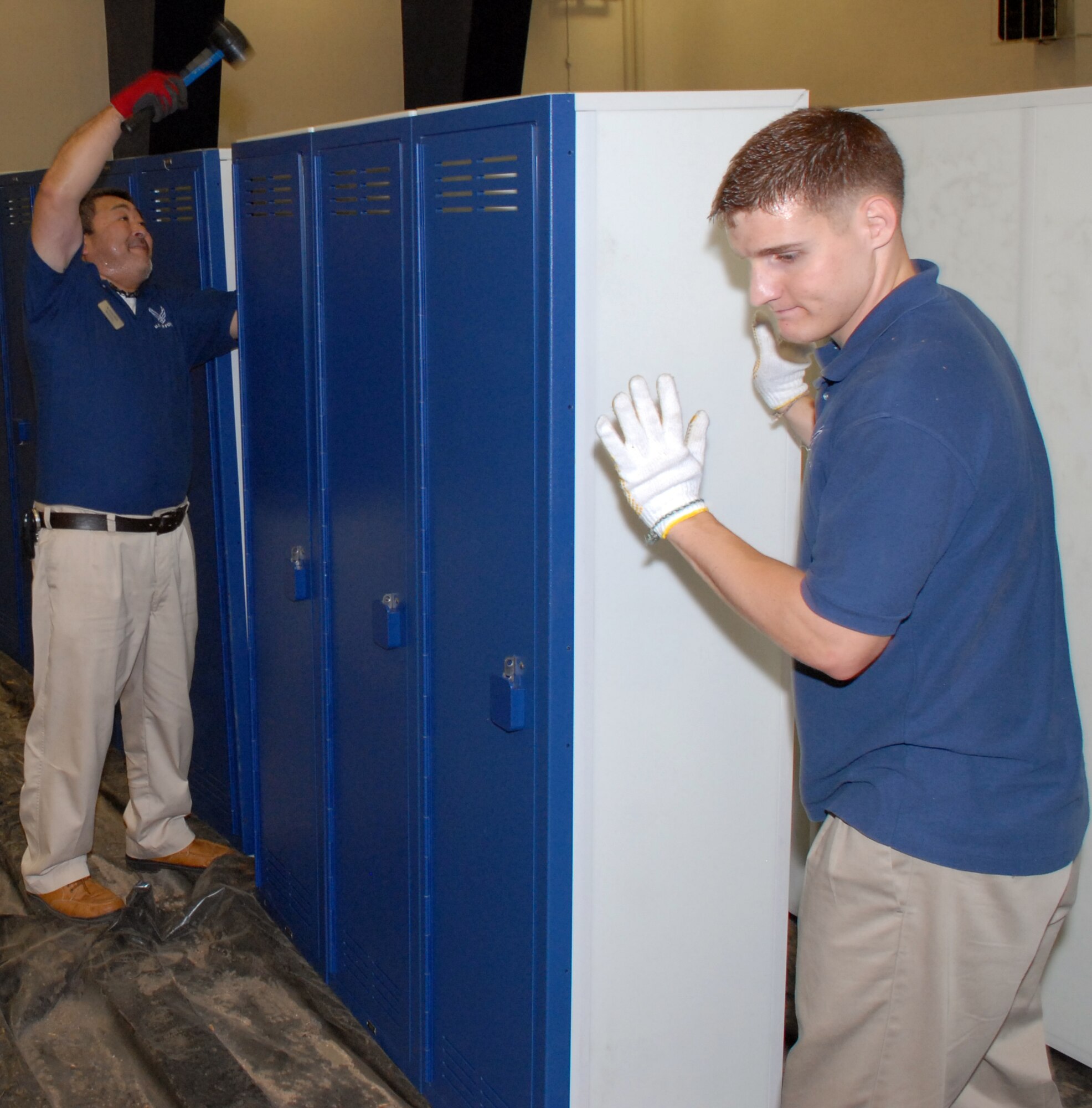 MISAWA AIR BASE, Japan -- Mr. Akira Obata, 35th Force Support Squadron maintenance specialist and Airman 1st Class Cody Laird, 35th FSS fitness specialist, straighten corners and panels on gym lockers June 19 at the Potter Fitness Center.  More than 300 lockers were moved to make way for the new floor in the East locker room. Total cost of the renovation is approximately $1 million. (Air Force photo /Staff Sgt. Phillip Butterfield)