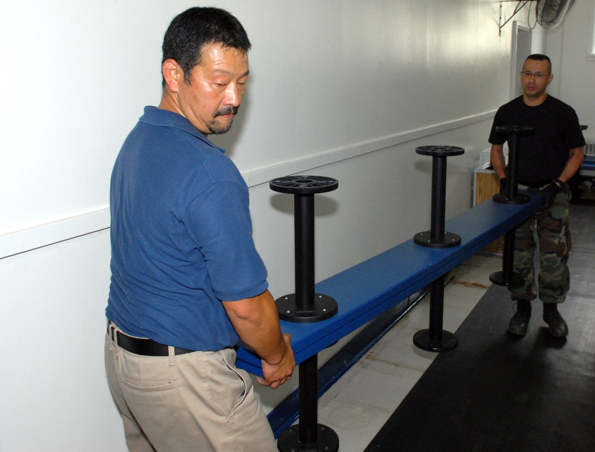 MISAWA AIR BASE, Japan -- Mr. Hiroki Hayashi, 35th Force Support Squadron recreation specialist and Tech. Sgt. Joji Johnson, 35th FSS fitness NCO in charge, carry benches out of the East locker room June 19 at the Potter Fitness Center. The East locker room will be receiving a new floor during the gym’s renovation project scheduled to be completed in October. Total cost of the renovation is approximately $1 million. (Air Force photo /Staff Sgt. Phillip Butterfield)