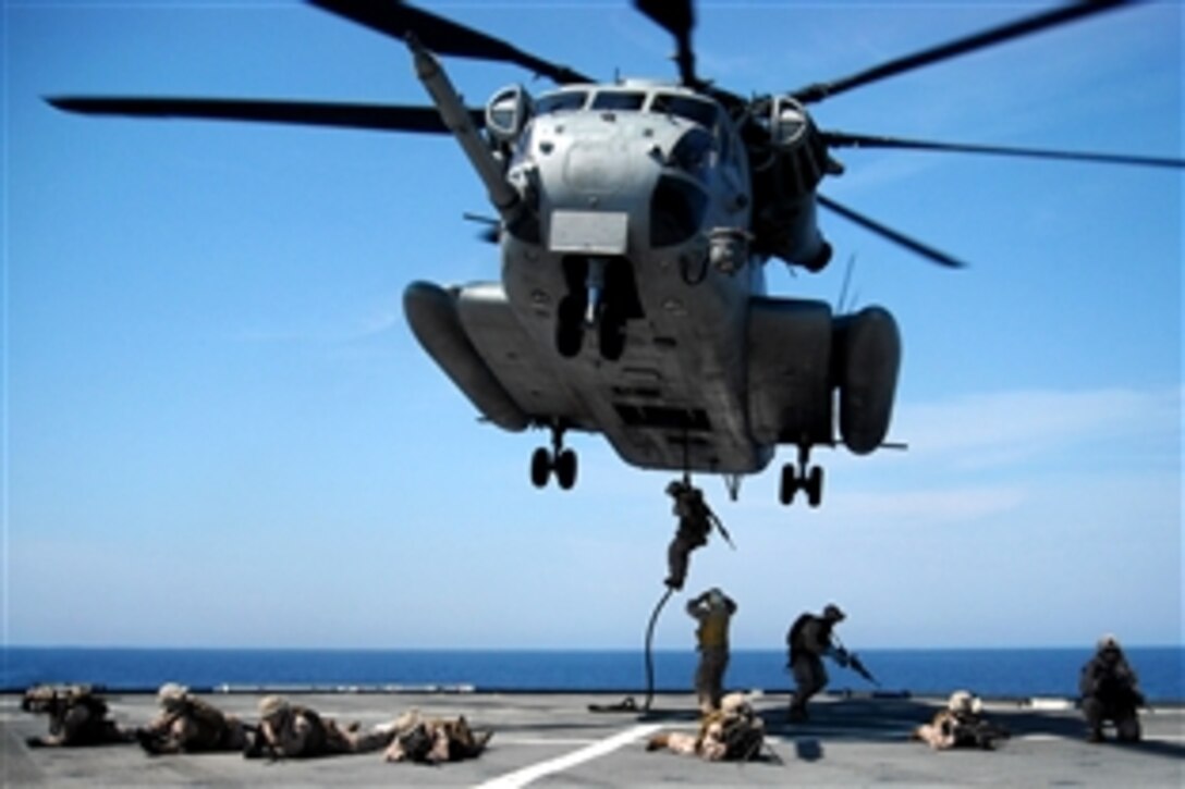 U.S. Marines set up security as their fellow Marines fast-rope to the deck of the USS Fort McHenry during a visit, board, search and seizure exercise in the 6th fleet area of operations, June 9, 2009. The Marines are assigned to the 22nd Marine Expeditionary Unit.