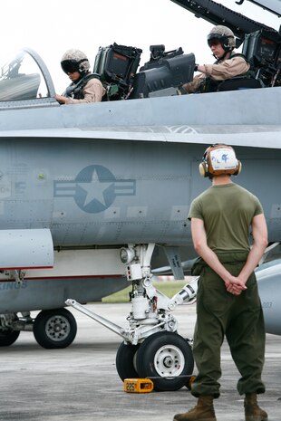 Capt. Marcus Yasumatsu, a pilot with Marine All-Weather Fighter Attack Squadron 225, and 1st Lt. Steve Bradford, a weapon systems officer with VMFA(AW)-225, park an F/A-18 for exercise Air Warrior 2009, a multi-lateral exercise demonstrating joint and multinational capabilities, and improving interoperability between the United States and Malaysia, here June 22. Yasumatsu and Bradford will be one of several pilot and WSO units pitted against a Malaysian squadron of Mikoyan MiG-29s for the exercise.