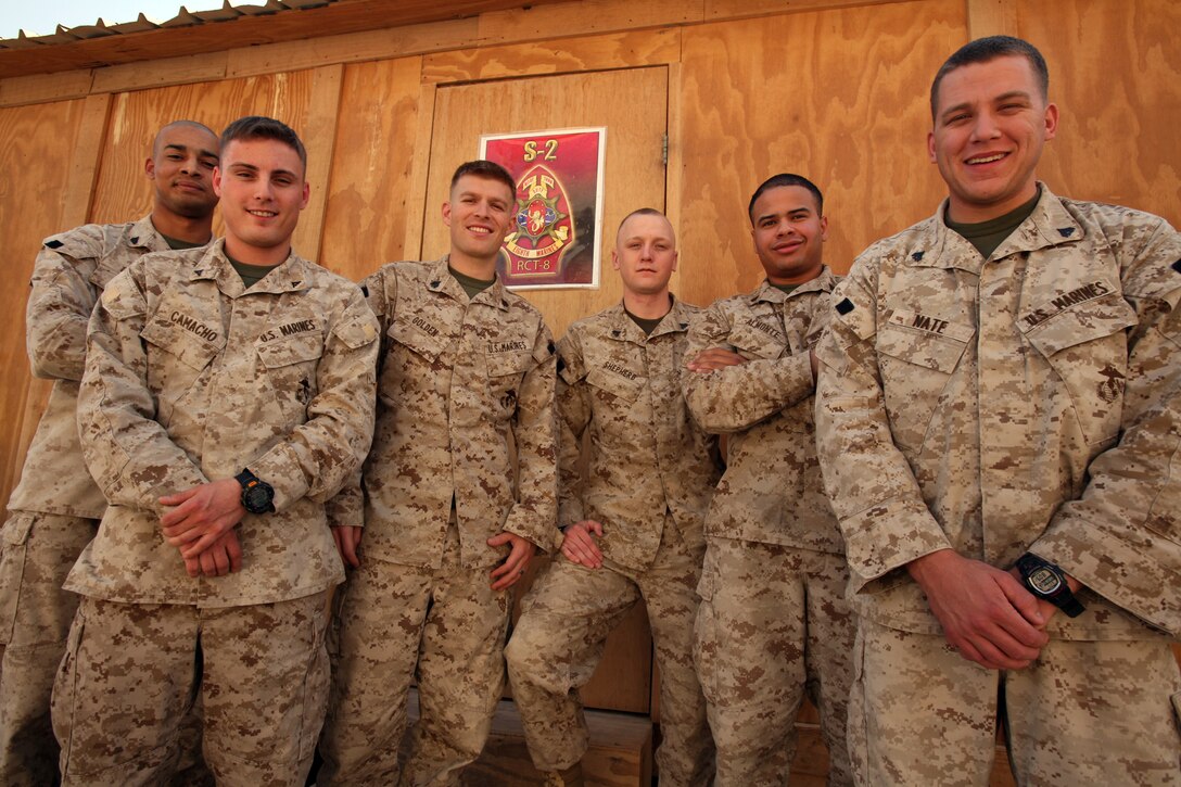 Marines with Intelligence section, Headquarters Company, Regimental Combat Team 8, stand proudly outside of their workspace during the early morning hours of shift changeover.  These Marines continuously collect and analyze information to make sure that RCT-8 Marines and attachments are well prepared for weather problems, any unsafe routes due to improvised explosive device activity and also provide data based information on the regiment’s area of operations.