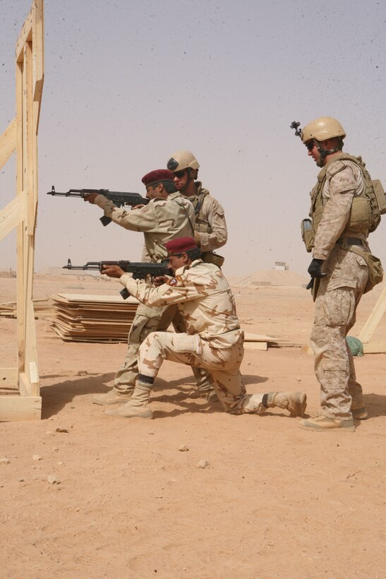 Marines with Reconnaissance Platoon, Regimental Combat Team 8, watch closely as two Iraqi commandos conduct the live-fire portion of their marksmanship training.  Although the commandos trained in various combat related exercises, special emphasis was placed on marksmanship, because of its importance in a combat situation.
