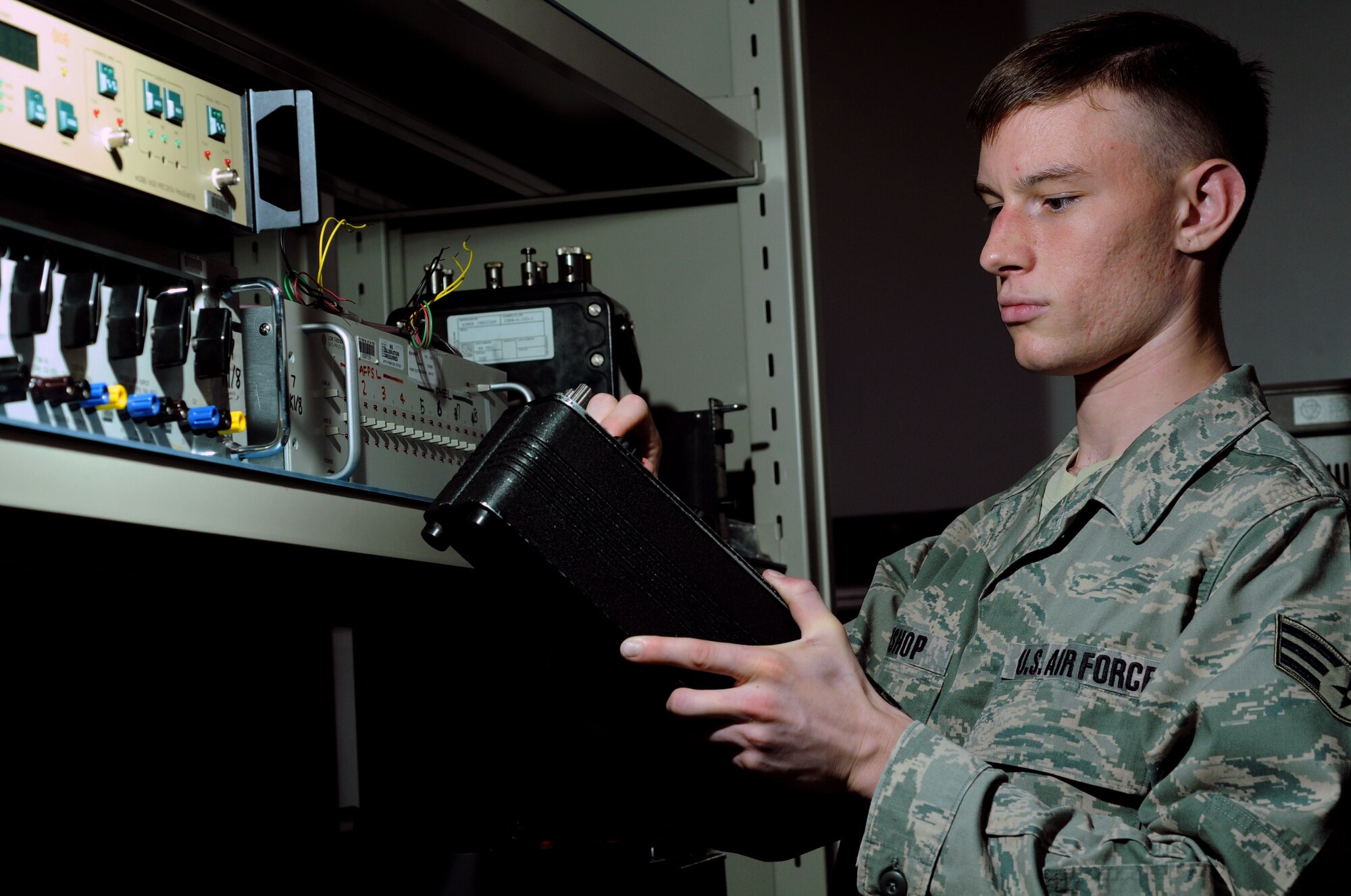 YOKOTA AIR BASE, Japan -- Senior Airman Paul Bishop, 374th Maintenance Squadron Precision Measurement Equipment Laboratory technician, inspects the variable range on a decade resistor box June 23, which is used to generate resistance values for calibration testing. PMEL technicians perform and manage repairs on test, measurement, and diagnostic equipment. (U.S. Air Force photo/ Staff Sgt. Veronica Pierce)