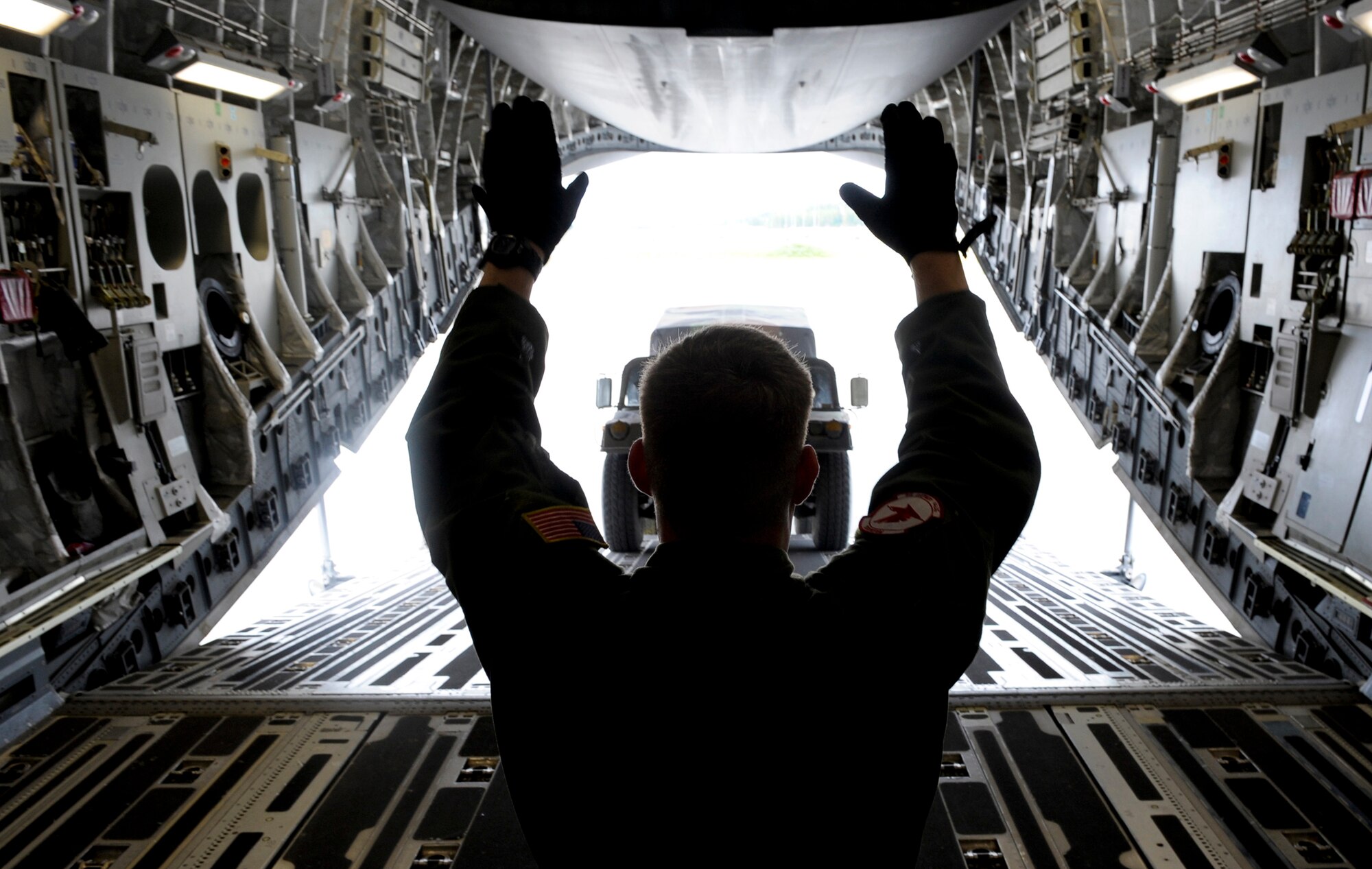 ELMENDORF AIR FORCE BASE, Alaska -- Tech. Sgt. Justin Mulder directs equipment onto C-17 Globemaster III during training for the upcoming Air Mobility Command Rodeo competition at McChord Air Force Base, Wash., in July. The international competition focuses on readiness, and features airdrops, aerial refueling and other events which will showcase the unique and wide-ranging capabilities of military security forces, and aerial port, maintenance and aeromedical evacuation personnel. Mulder is loadmaster with the 517th Airlift Squadron. (U.S. Air Force photo/Master Sgt. Keith Brown)