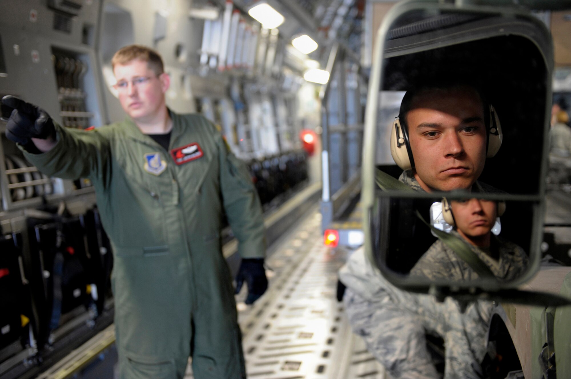 ELMENDORF AIR FORCE BASE, Alaska -- Airman 1st Class Westin Smith waits for direction from Tech Sgt. Justin Mulden before backing off a HUMVEE from a C-17 Globemaster III during training for the Air Mobility Commands Rodeo competition. The international competition focuses on readiness, and features airdrops, aerial refueling and other events which will showcase the unique and wide-ranging capabilities of military security forces, and aerial port, maintenance and aeromedical evacuation personnel. Smith is a member of the 3rd Logistics Readiness Squadron and Muldon is a loadmaster assigned to the 517th Airlift Squadron here. (U.S. Air Force photo/Master Sgt. Keith Brown)