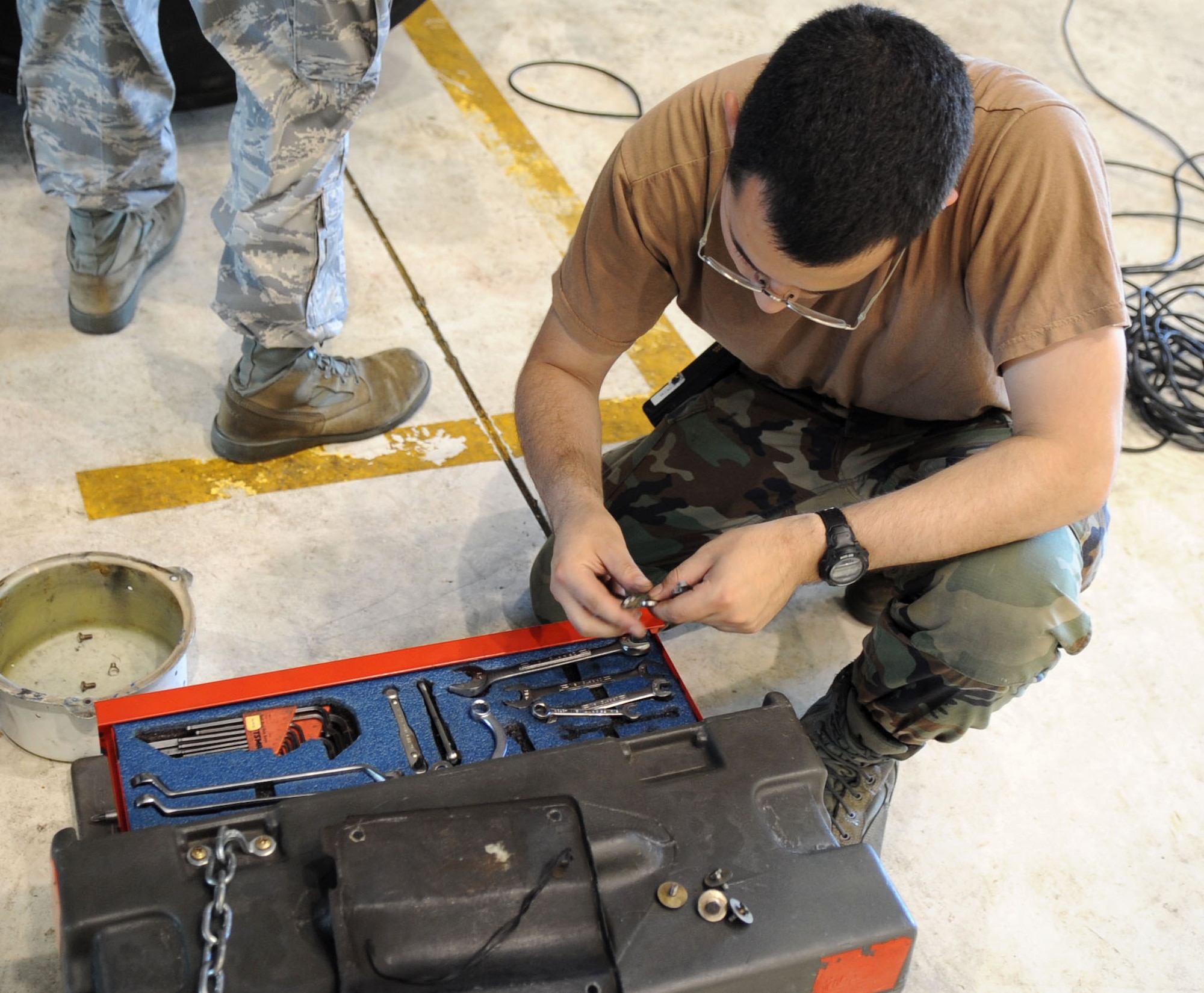 Senior Airman Nicholas Lou, 2nd Expeditionary Aircraft Maintenance Unit electrical environmental journeyman, searches for a tool to repair the landing gear on a B-52 Stratofortress bomber June 16.   The Warren, R. I., native is deployed here from Barksdale Air Force Base,  La., to support U.S. Pacific Command's Continuous Bomber Presence in the Asia-Pacific Region
(U.S. Air Force photo/ Christopher Bush)
