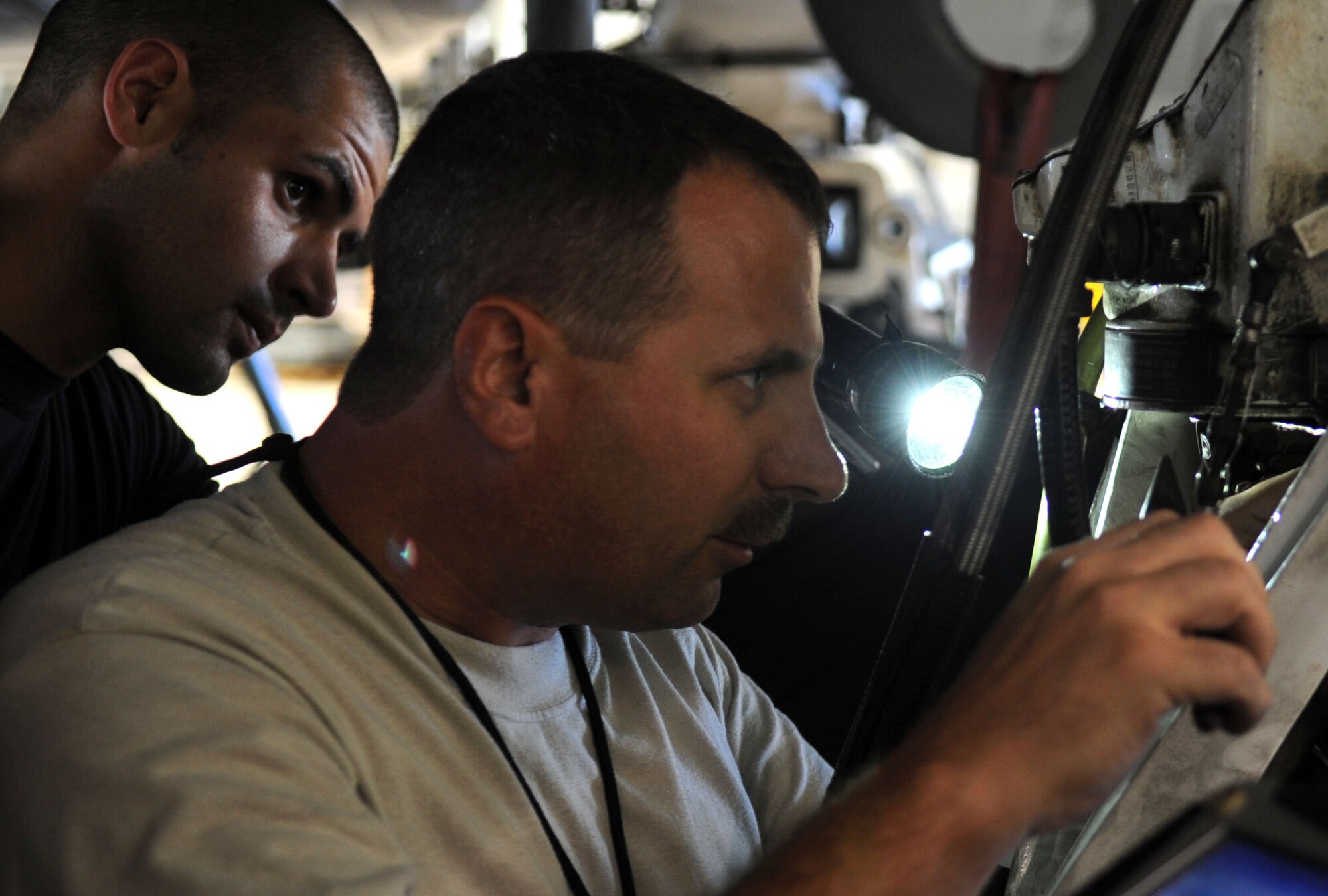 Airman 1st Class Charlie T. Lord, electrical environmental specialist, and Master Sgt. Joseph G. Godwin, specialist section chief, 2nd Expeditionary Aircraft Maintenance Unit, work together to connect wires to a position control unit to repair landing gear on a B-52 Stratofortress bomber June 16.  The Airmen are deployed here from Barksdale Air Force Base,  La., to support U.S. Pacific Command's Continuous Bomber Presence in the Asia-Pacific Region (U.S. Air Force photo / Christopher Bush)
