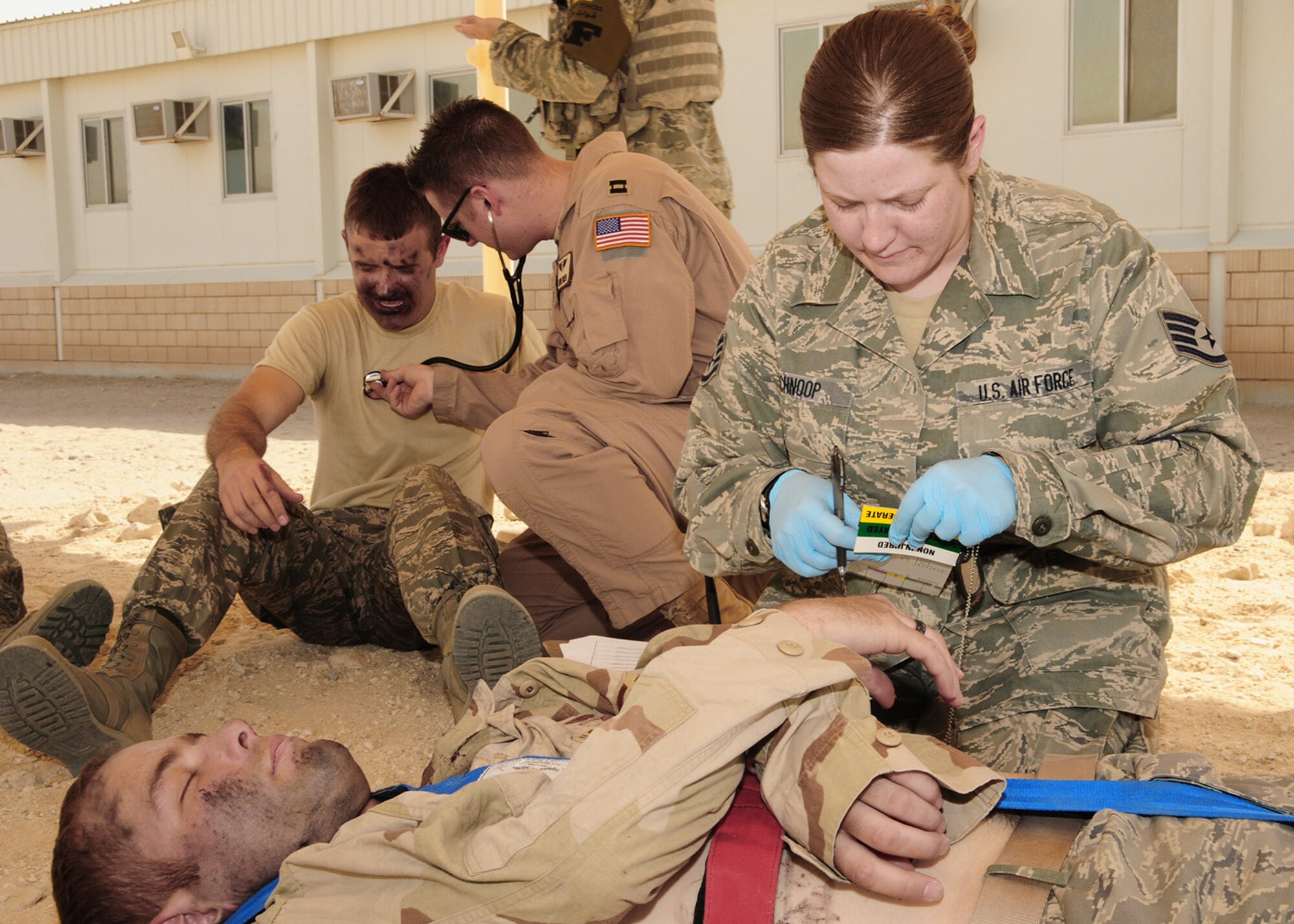 Staff Sgt. Betty Schnoop labels a simulated victim as immediate response due to a life threatening injury, while Capt. Layne Green checks the lungs of a simulated burn victim during a dorm fire exercise June 22 at an air base in Southwest Asia, June 22. A triage tag is a tool first responders and medical personnel use during mass casualty incidents to identify the victims and to prioritize the severity of their injury. Sergeant Schnoop is assigned to the 386th Expeditionary Medical Group and deployed from Wright-Patterson Air Force Base, Ohio. She is a native of Albany, N.Y. Captain Green is assigned to the 386th Expeditionary Medical Group and deployed from Brooks City-Base, Texas. He is a native of Meridian, Idaho. (U.S. Air Force photo/Senior Airman Courtney Richardson)