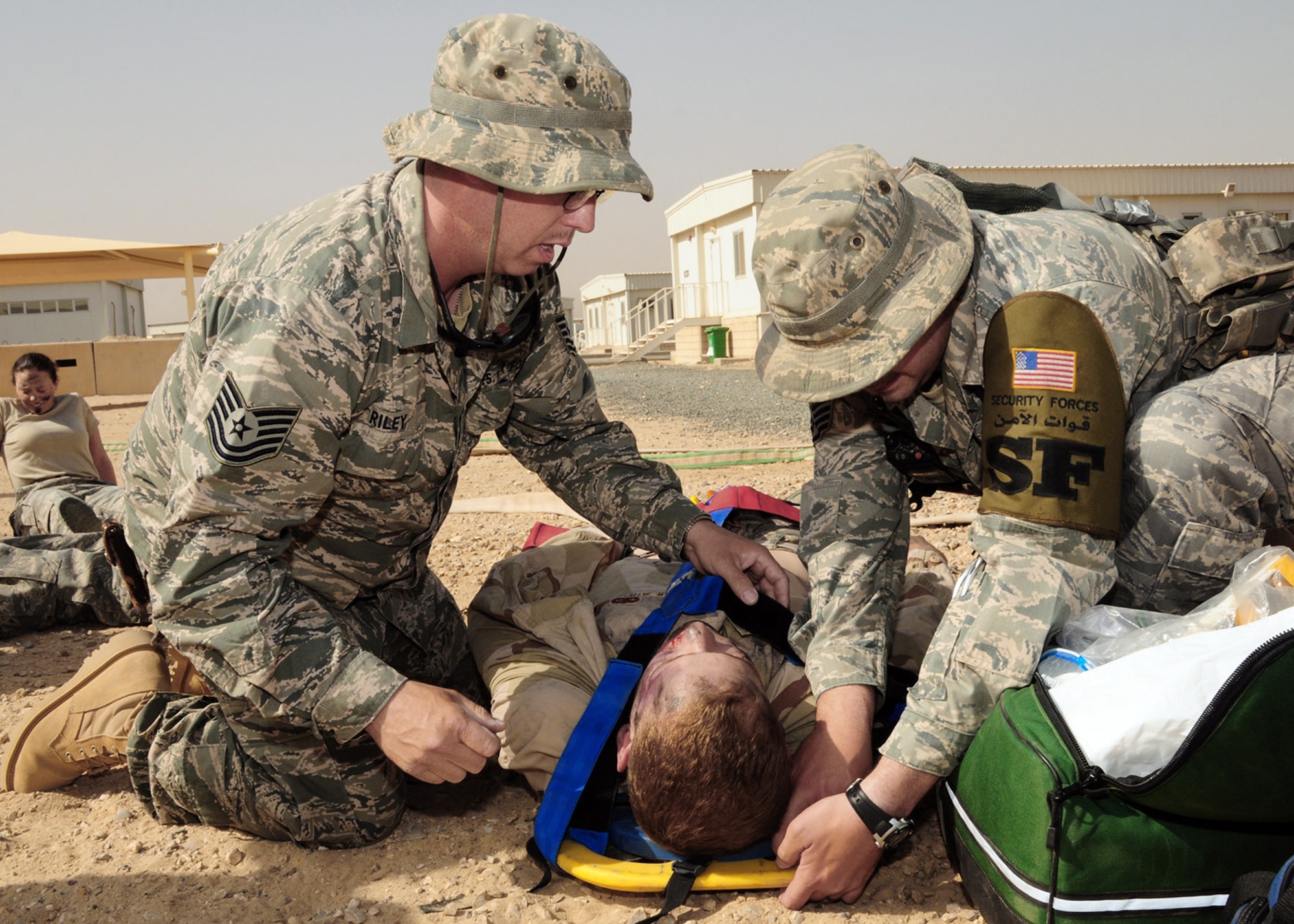 Emergency personnel strap down a simulated patient to a back board after recovering him from a simulated dorm fire during a June 22 exercise at an air base in Southwest Asia. The exercise was performed to evaluate the first responders as well as the command and control notification process. (U.S. Air Force photo/Senior Airman Courtney Richardson)