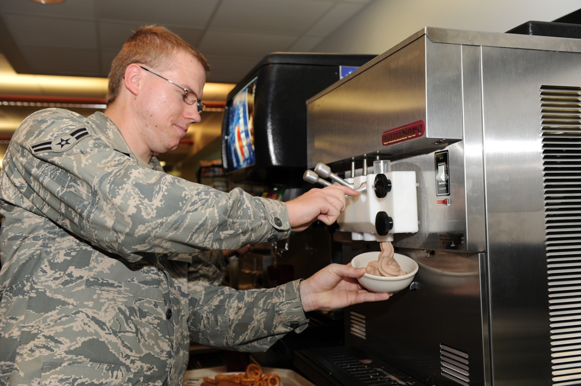 WHITEMAN AIR FORCE BASE, Mo. - Airman 1st Class Steven Carpenter, 509th Mission Support Group, knowledge operations management, enjoys the Ozark Inn’s new soft serve ice cream machine, June 19. Along with the chocolate soft serve, Ozark Inn serves Nestle ice cream bars and cakes and pies for dessert. (U.S. Air Force Photo/ Airman 1st Class Carlin Leslie)