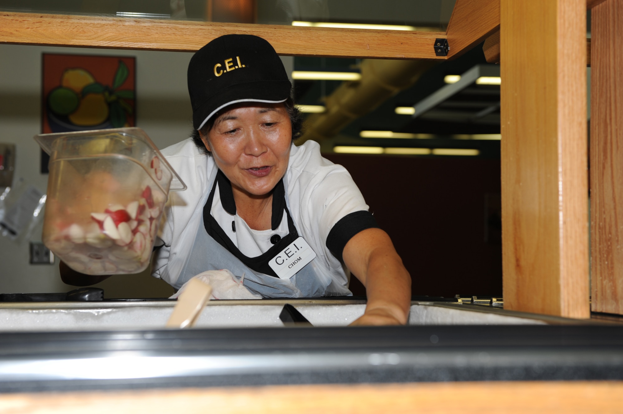 WHITEMAN AIR FORCE BASE, Mo. - Chom Millington, Ozark Inn civilian contractor, replenishes the salad bar with radishes, June 19. The Ozark Inn Dining Hall serves a variety of foods for breakfast, lunch, dinner and midnight meal to accommodate Airmen. (U.S. Air Force photo/Airman 1st Class Carlin Leslie)