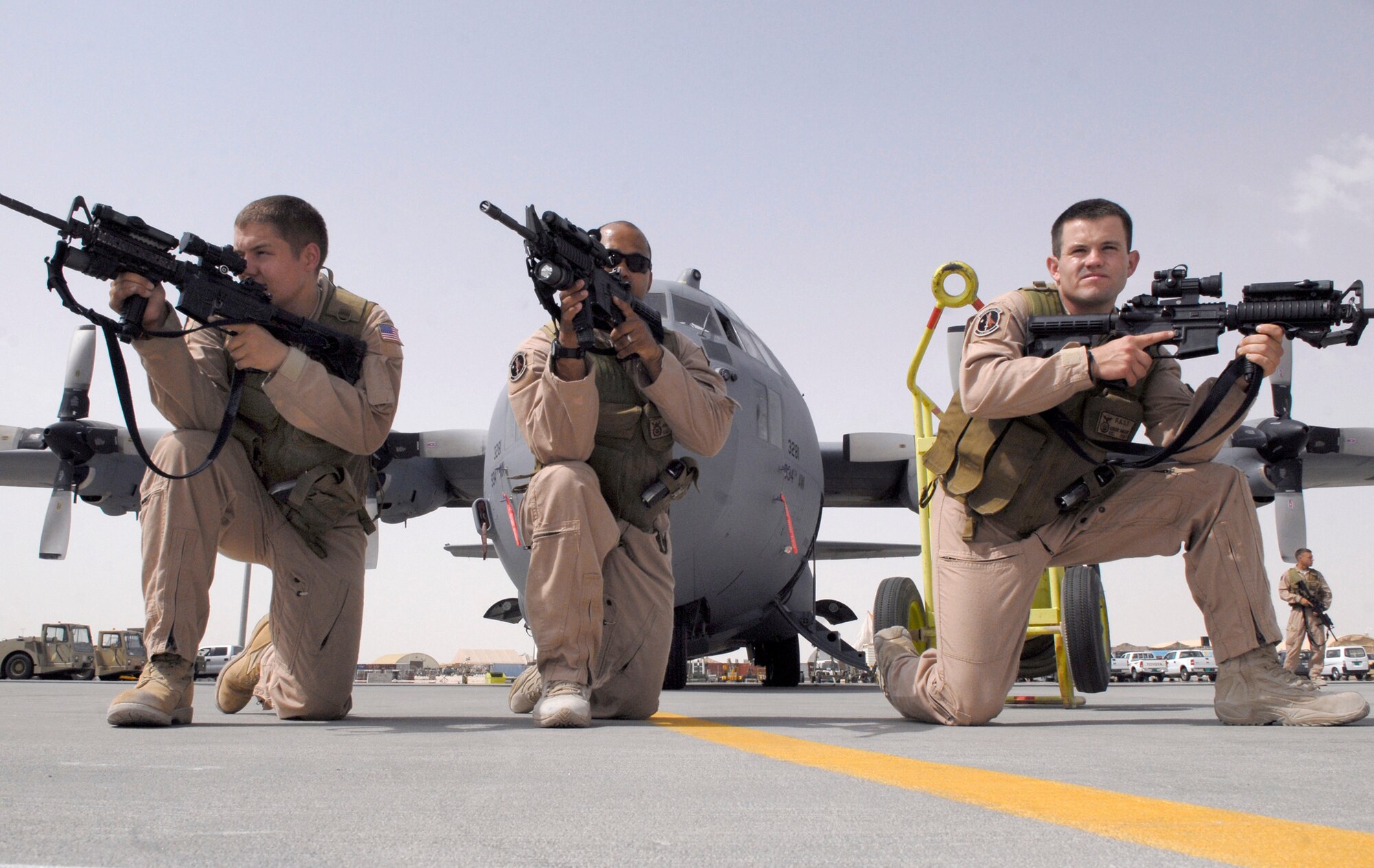 Airman 1st Class Corey Davis, Staff Sgt. James Booker and Airman 1st Class Robert Hansen post in the front of a C-130 Hercules during a training exercise June 18 at an air base in Southwest Asia. Airman Davis is a 379th Expeditionary Security Forces Squadron fly-away security team member. Sergeant Booker is a 379th ESFS FAST leader. Airman Hansen is a 379th ESFS FAST member. (U.S. Air Force photo/Senior Airman Andrew Satran)