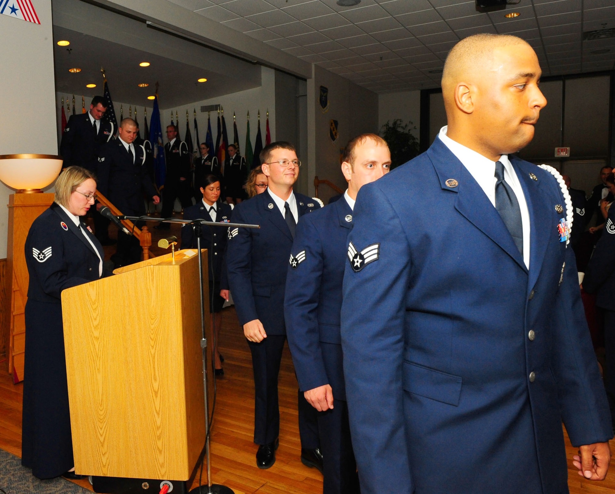 DYESS AIR FORCE BASE, Texas -- Airman Leadership School graduates here leave the stage June 18 after singing the Air Force song to end the ceremony. The primary instructional methodology in ALS is the guided discussion. Instruction covers three broad academic areas: profession of arms, communication skills and leadership. Flight chief’s time and collateral curriculum round out the course. (U.S. Air Force photo by Staff Sgt. Connor Estes)