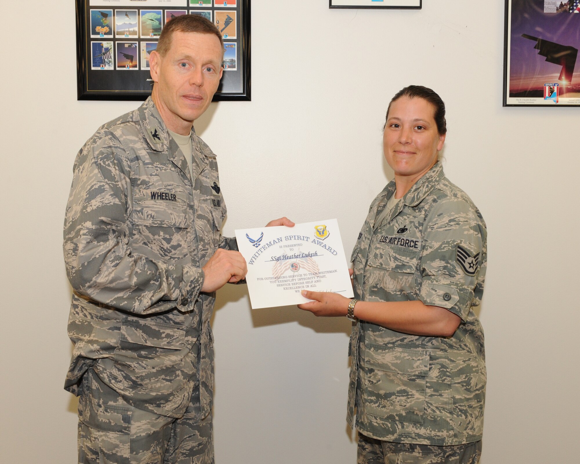 WHITEMAN AIR FORCE BASE, Mo.- Col. Robert Wheeler, 509th Bomb Wing commander, presents Staff Sgt. Heather Lukesh, 509th Logistics Readiness squadron, with the Whiteman Spirit Award, June 17. (U.S. Air Force photo/ Airman 1st Class Carlin Leslie)