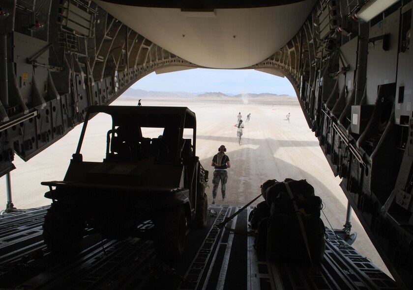 Aerial porters from the 615th Contingency Response Wing quickly deplane a Travis C-17 Globemaster III after uploading equipment at Fort Irwin's Bicycle Lake, Calif., June 15.  Bicycle Lake was one of four operating locations during the 615th CRW's annual HYDRA training venue June 12-21, which included participants from multiple Air Force, Army and Marine units from across the country. (U.S. Air Force photo/1st Lt. Nicole Langley)
