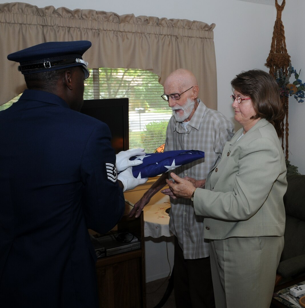 Tech. Sgt. Michael Nelson, Air Force Personnel Center, presents a flag to retired Tech. Sgt. Billy Oldham and his daughter, Sherrill, in honor of his many years in service to his country. Randolph Air Force Base Airmen volunteered to perform the special ceremony at the request Sergeant Oldham?s daughter. (U.S. Air Force photo by Don Lindsey)