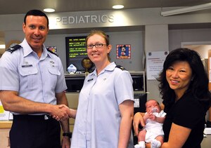 Colonel Steven Shepro, 316th Wing commander, coins Maj. Melinda D. Batman, 779th Medical Operation Squadron pediatric medical director, with his wife, Helen, and son, Jonathan, at the Pediatric clinic Monday. Colonel Shepro praised the Pediatrics Clinic, as well as Lt. Col. Marc Hester, Maj. Kent Meldrun, 1st Lt. Chanell Mitchell, Airman Joseph Schiavone and the labor and delivery staff, who successfully delivered Jonathan. “It’s great to see firsthand the superb level of care provided to all our Team Andrews members, of all ages!” said Colonel Shepro. (U.S. Air Force photo/ Senior Airman Renae Kleckner)