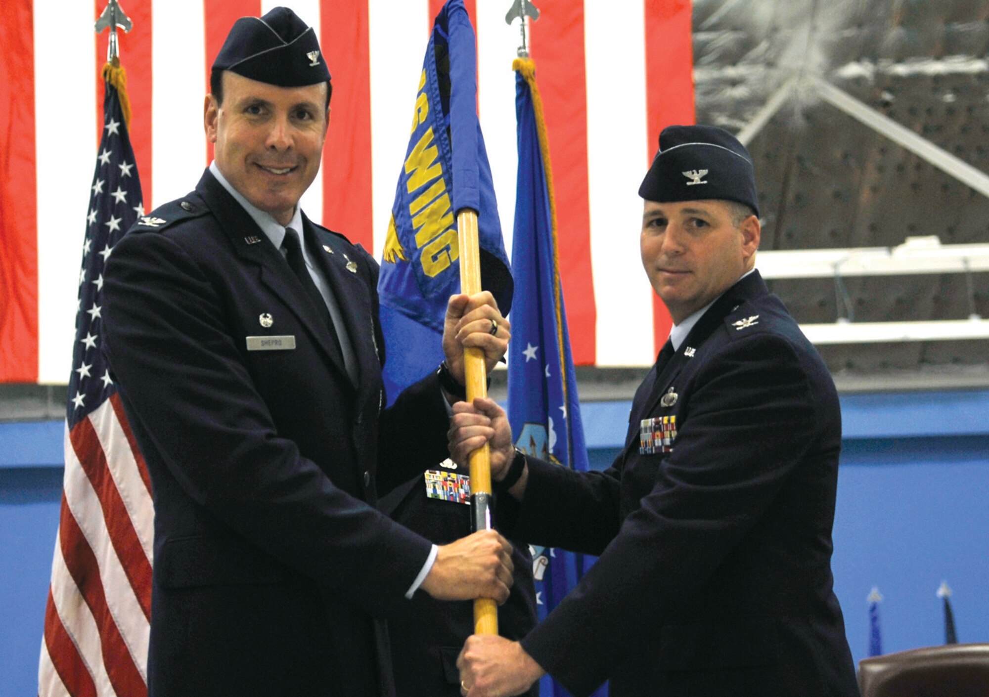 Colonel Steven Shepro, 316th Wing commander, hands the guidon to Col. John Long during the 316th Mission Support Group change of command ceremony June 12 in Hangar 3. Colonel Long has come to Andrews from Barksdale Air Force Base, La. (U.S. Air Force photo/ Senior Airman Renae Kleckner)