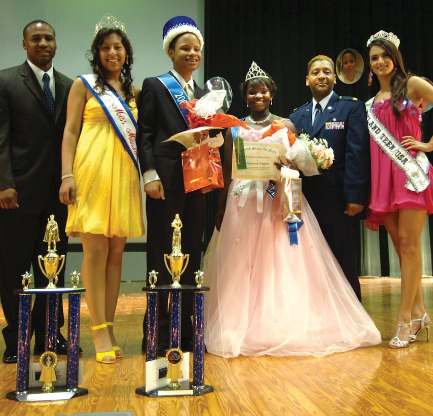Surrounded by judges, Mathias Bradley, 13, and Zipporah Wiggins, 15, center, pose for photos after being selected as the 2009 Mr. and Mrs. Teen Andrews Pageant winners at the Reel Time Base Theater Saturday. Mr. Mathias is the son of Master Sgt. (ret.) Wilbert Bradley, and Ms. Zipporah is the daughter of Maj. (ret.) Avril Wiggins. (U.S. Air Force photo/ Bobby Jones)