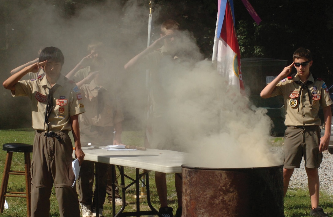 Boy Scout Troop 688, Pack 88, renders the Boy Scout salute while observing the smoke from the burning remains of more than 100 United States flags during the closing moments of an official flag retirement ceremony held at the American Legion Post 162, in Lorton, Va., on Flag Day. The flags were donated to the troop from members of their local communities. (U.S. Air Force photo/ Bobby Jones)