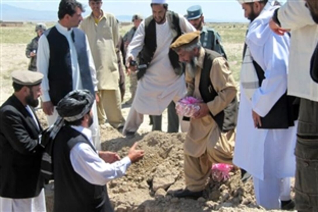 U.S. troops attend a ground-breaking ceremony in which Gulab Shah, Zormat sub governor, hands Paktia Deputy Governor Mangal the ceremonial cornerstone for new Zormat District Education Center in Zormat, Afghanistan, June 21, 2009.